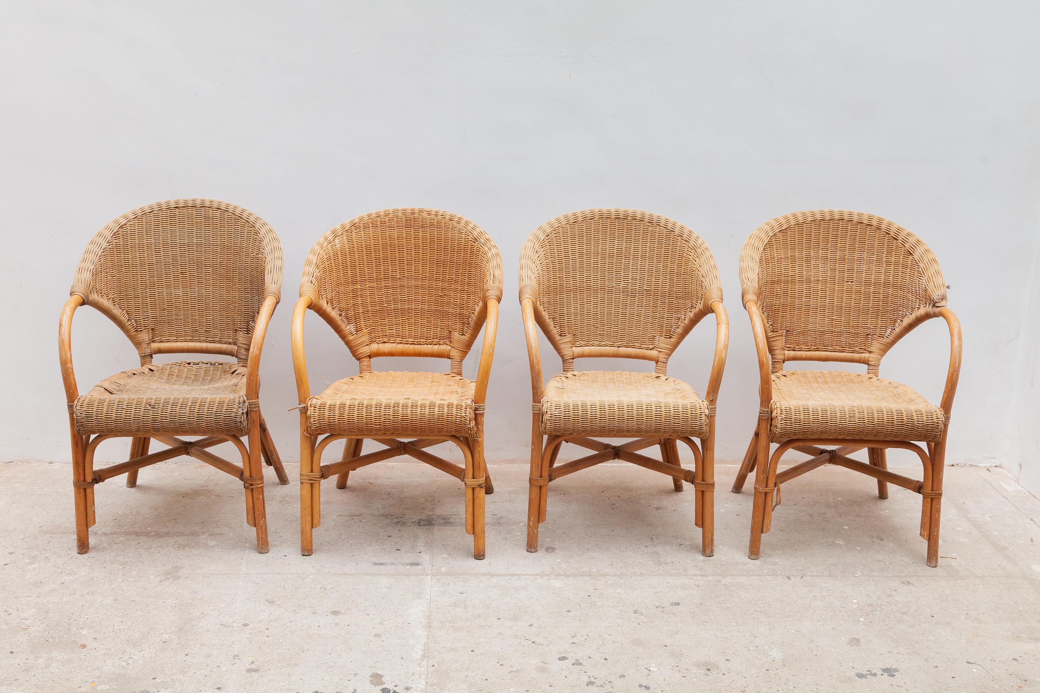 1970s Italian set of four armchairs in rattan wicker and bamboo. This charming lounge chairs are in the typical Riviera style where the organic beauty of the woven materials is timeless and Classic. These chairs feature a lightweight bamboo frame