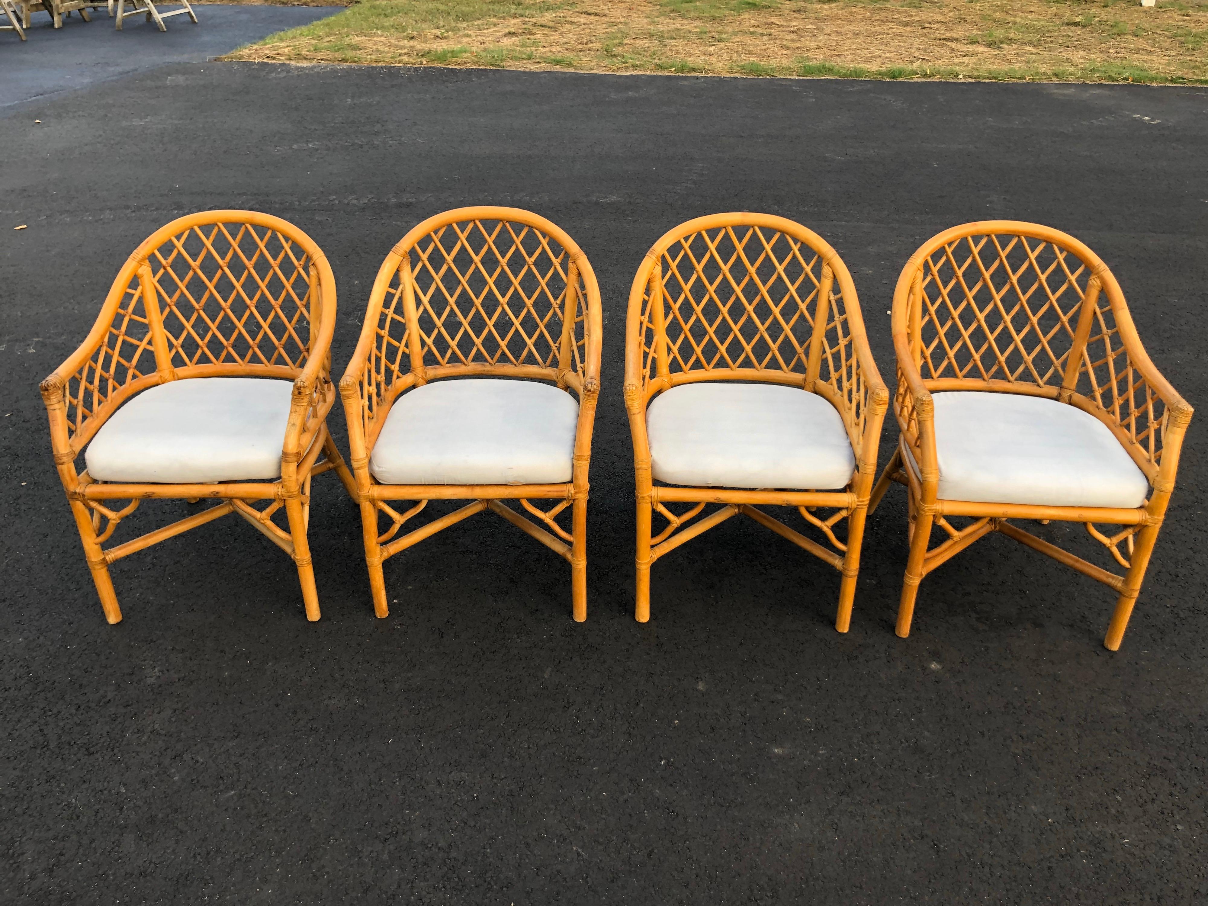 Set of four bamboo chairs in the style of McGuire. They each have an off white/beige seat cushion. Boho chic style with a casual coastal look.

One matching dining table and one side table available with various size glass tops.
  