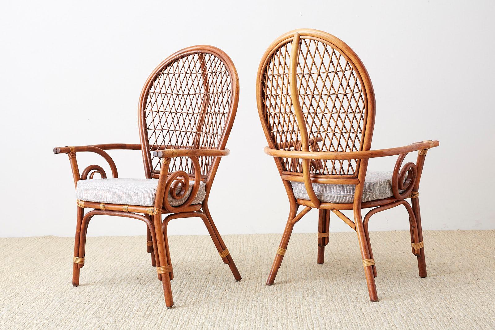 Midcentury set of four peacock or fanback dining armchairs. Made in the Hollywood Florida Regency style from bamboo rattan poles. Featuring a balloon back with an open lattice fretwork design. The flat horseshoe arms have a double bamboo pole with a
