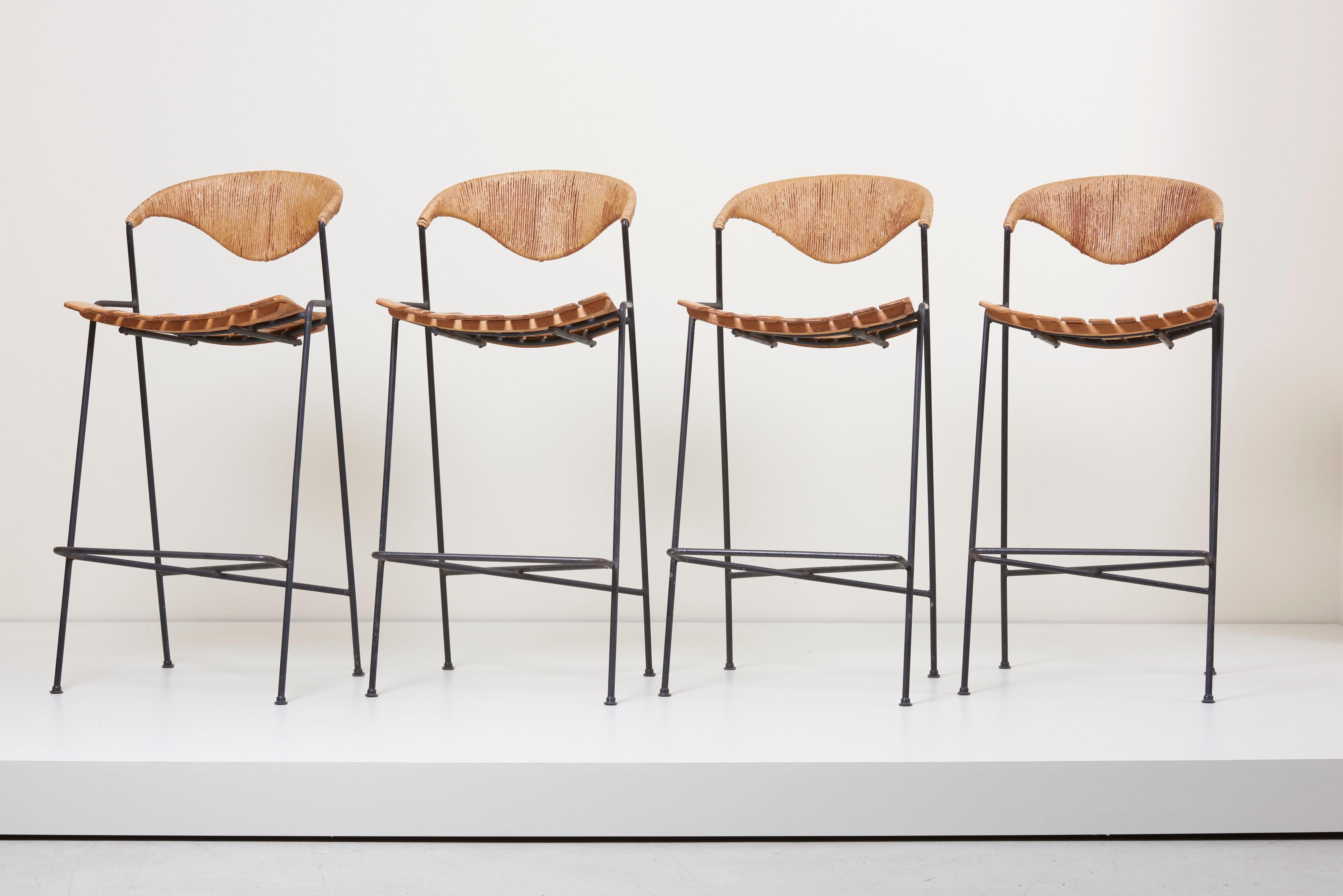 Set of four barstools by Arthur Umanoff for Raymor.
Iron bases with rushed back and wood slatted seats.



  