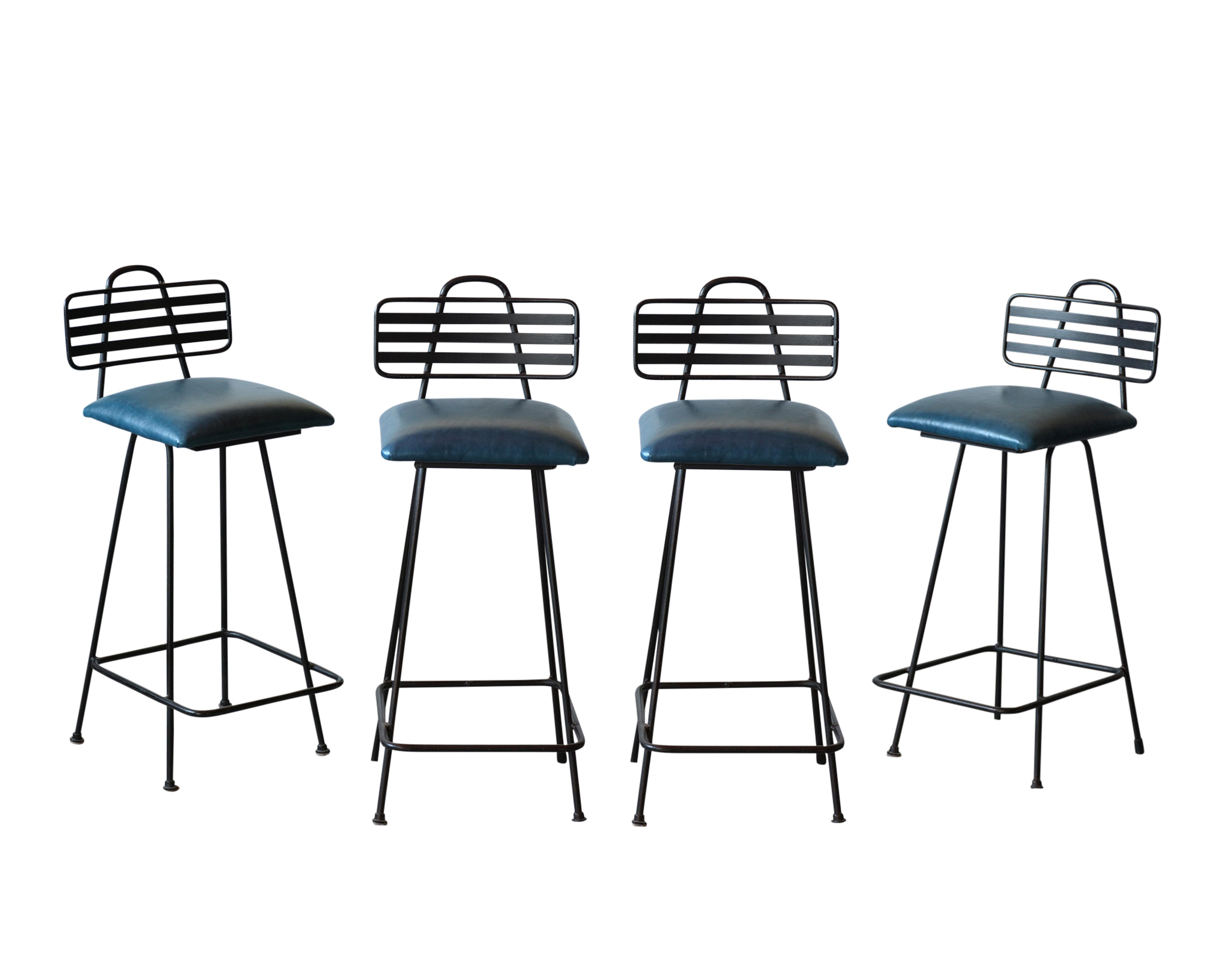 These Four Mid-Century Leather Bar Stools are made out of wrought-iron, feature a Harpin backrest design, and rest on stretched legs frame newly painted in black color. The seats have all been upholstery in blue color leather with new comfortable