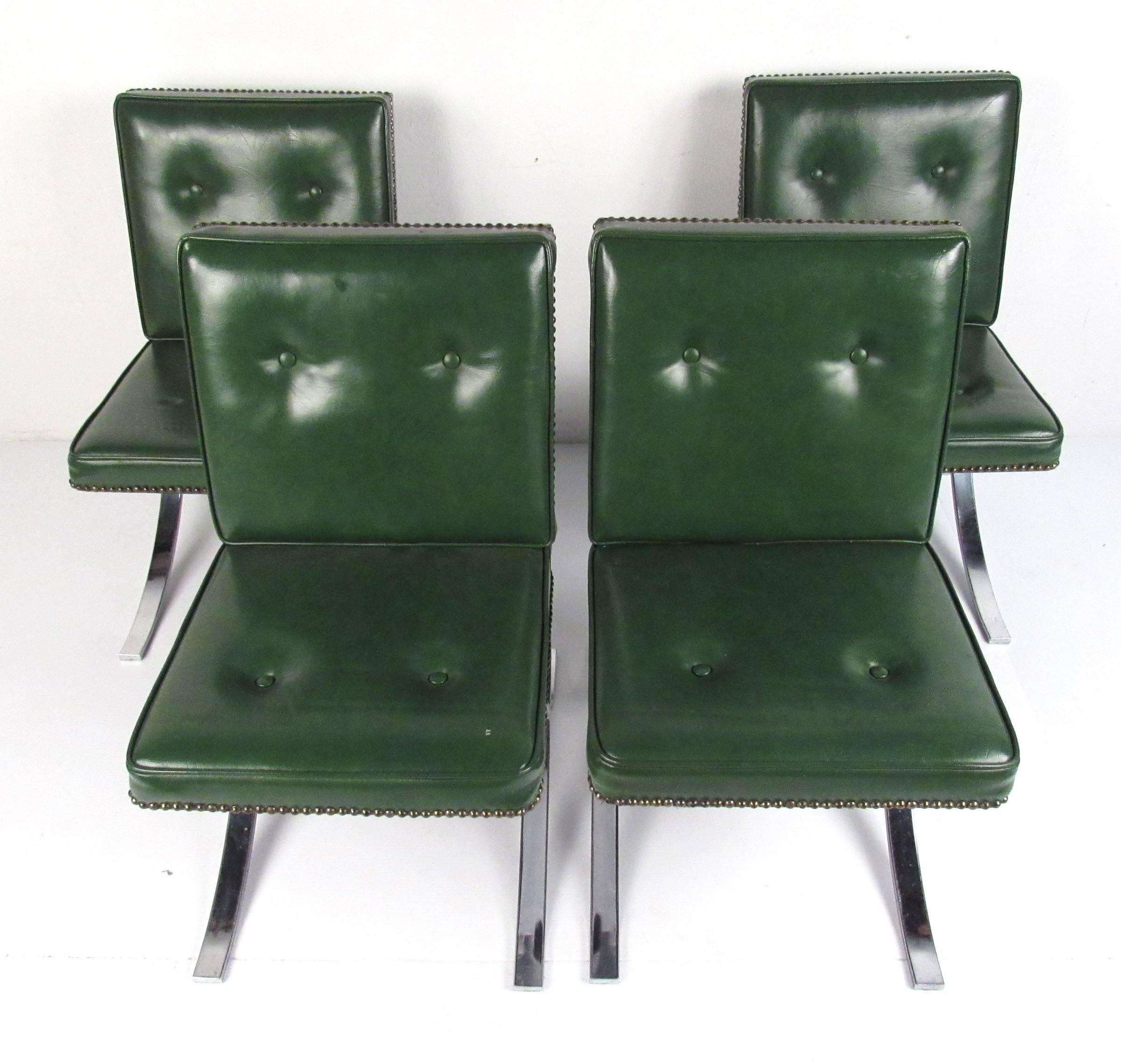 In the style Mies' Barcelona chair, these stylish green vinyl and chrome chairs make great dining or side chairs in any modern setting. The glossy green vinyl is nicely contrasted by the decorative brass tacks and the gentle curves of the chrome