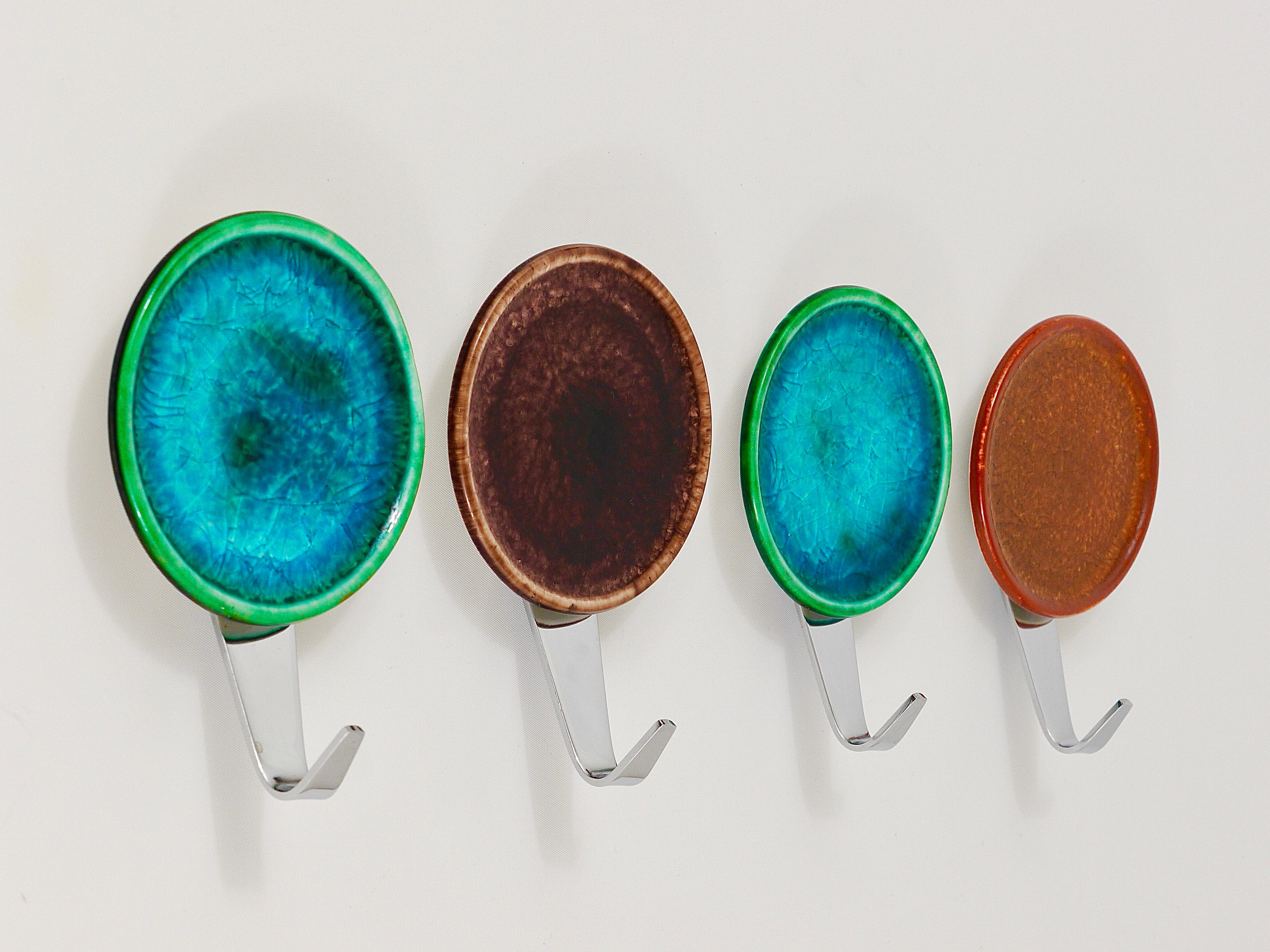 A set of four colorful wall hooks, executed in Italy in the 1960s. Made of chrome-plated brass with colorful round enameled ceramic covers. In very good condition.