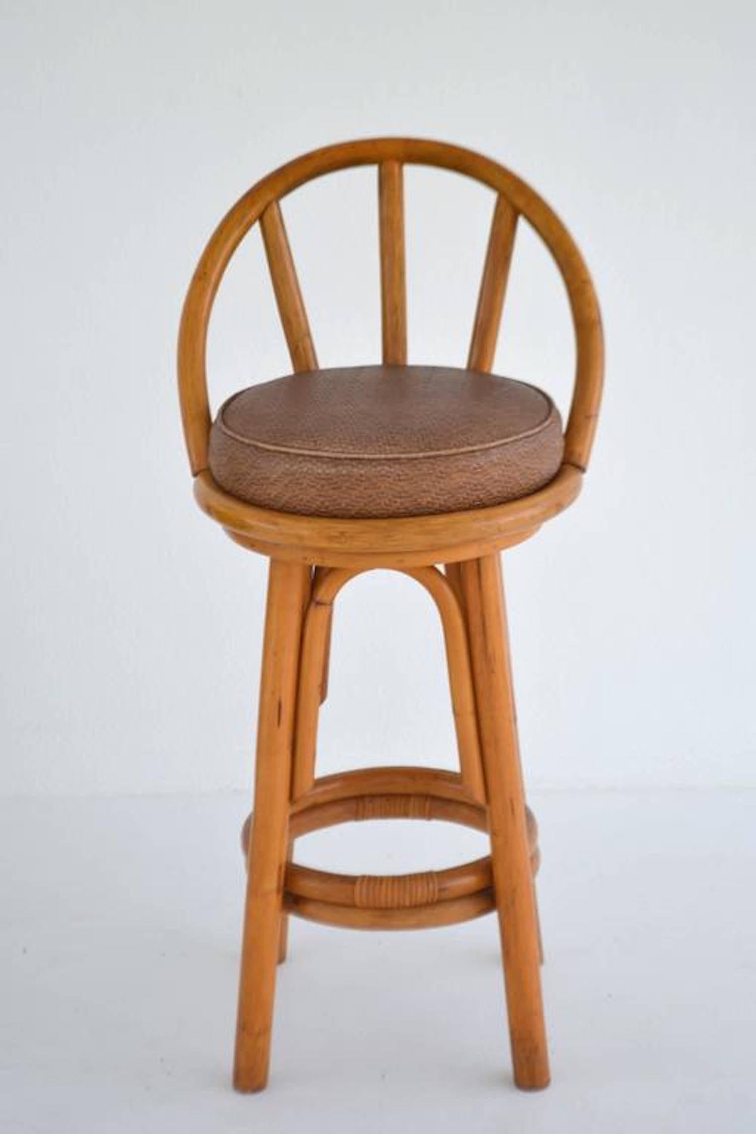 Striking set of four midcentury bent bamboo swivel seat bar stools, circa 1950s-1960s. These sculptural bar stools are designed with woven leather seats.

Measurements
40.5