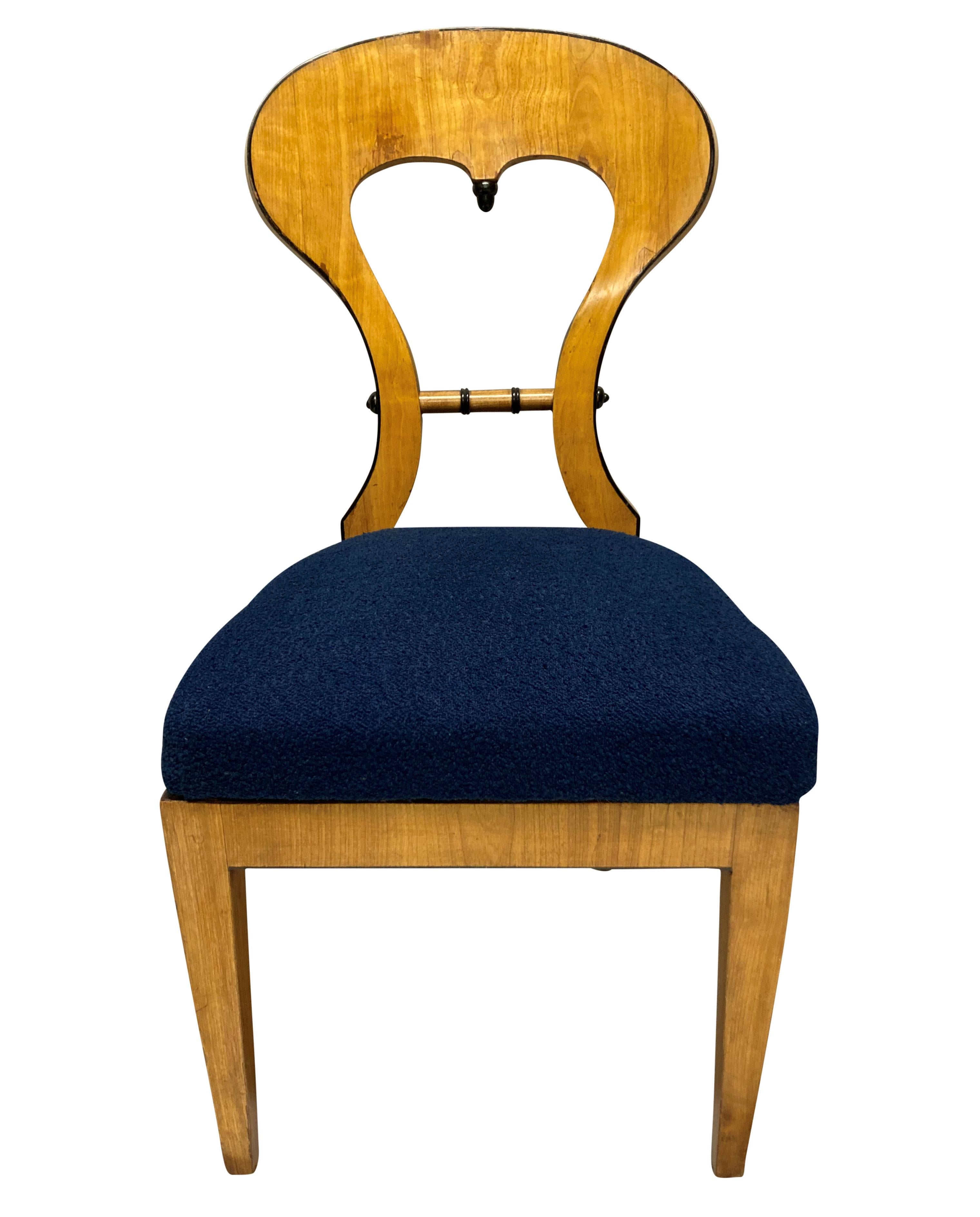 A set of four Austrian Biedermeier chairs in satinwood with ebonised detailing. Newly upholstered in blue boucle.