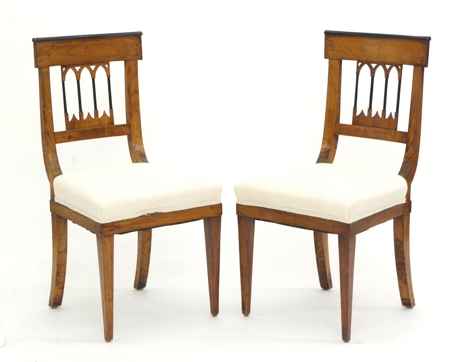 Set of four Biedermeier cherrywood side chairs, each with a tablet crest with Bookmatched veneers and ebonized molding over a Gothic splat; the upholstered seats on square tapering legs. Ideal for a breakfast room or card table.