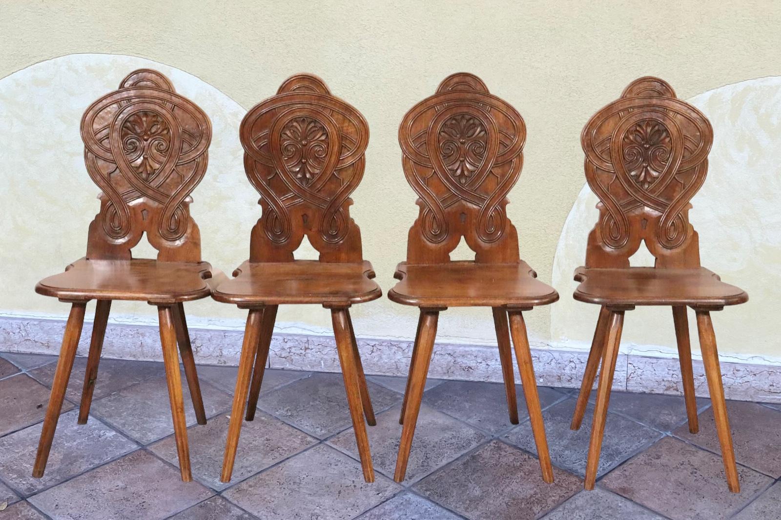 A set of four interesting brutalist wood carved from the Bavarian Alps or Black Forest Area , with a motif adorning all chair Backrests. Each Stool is in very good, used condition, the backrests and legs are maybe a bit wobbly, that comes from the