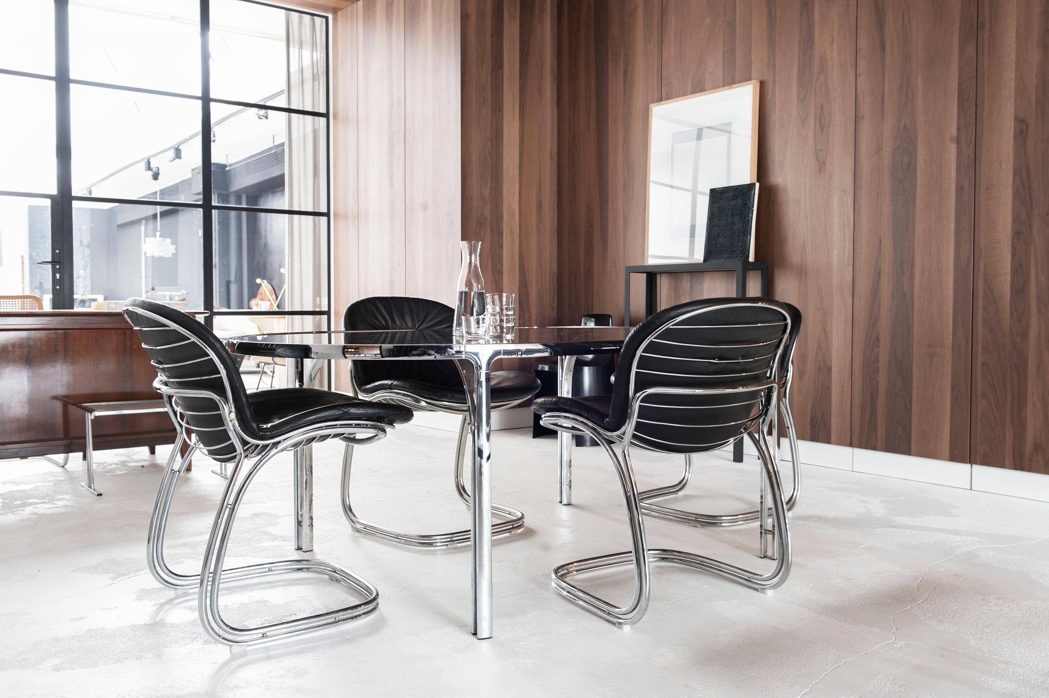Set of four black Italian Sabrina chairs and glass table by Gastone Rinaldi for Rima. This set of four ‘Sabrina’ chairs and smoked glass table were designed by Gastone Rinaldi for Rima in Padove Italy during the 1970s. The cantilevered chairs