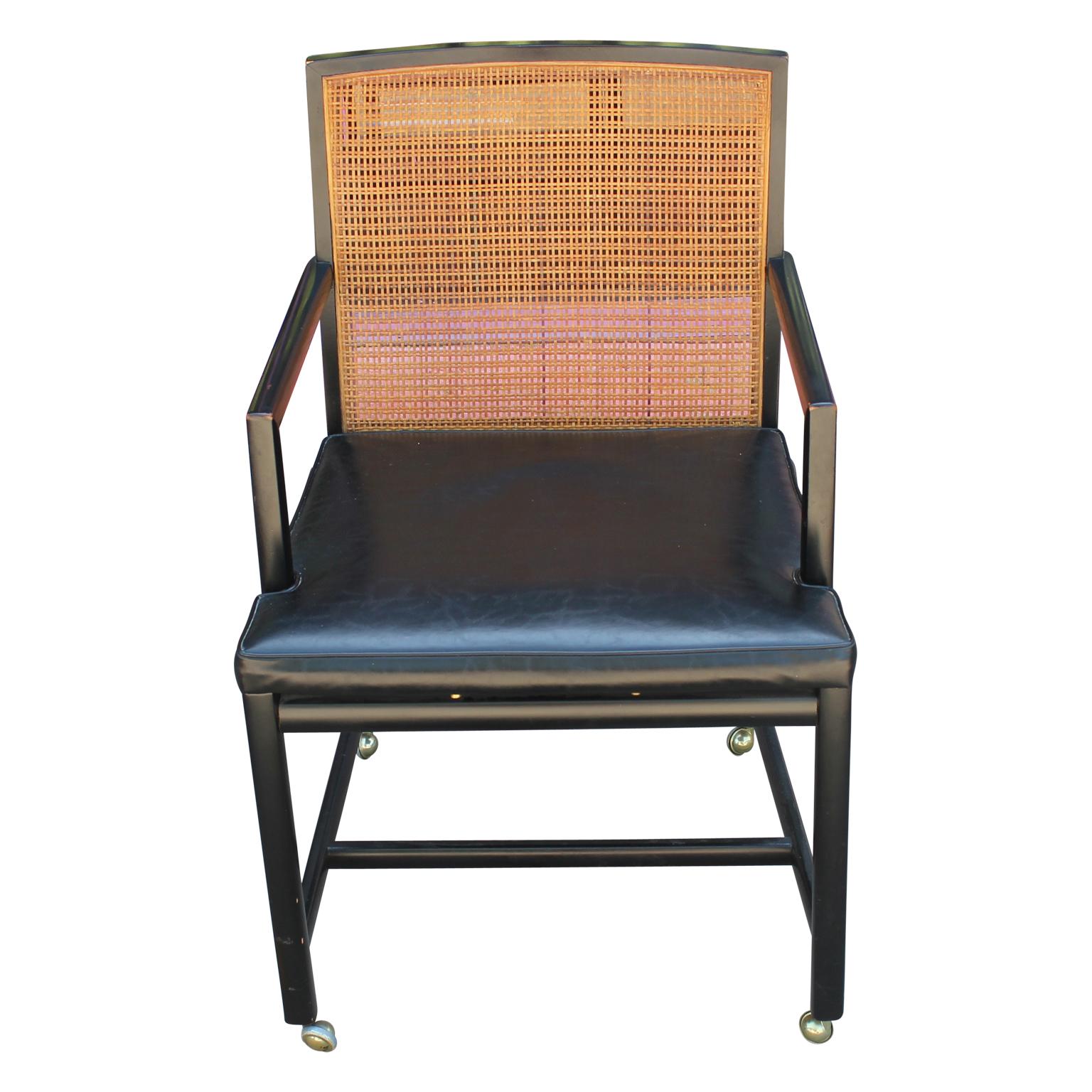 Wonderful set of four dining chairs by Michael Taylor for Baker Furniture and New World Collection. They are lacquered black and are cane backed. We recommend recaning the chair backs. We currently have two arm chairs and two side chairs in this