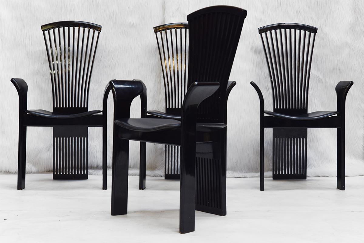 Wonderful set of 4 black lacquered dining room chairs with leather seats designed by Pietro Costantini. The four Italian modern dining room chairs with armrests were made in the 1980s. Very stylish pieces.
  