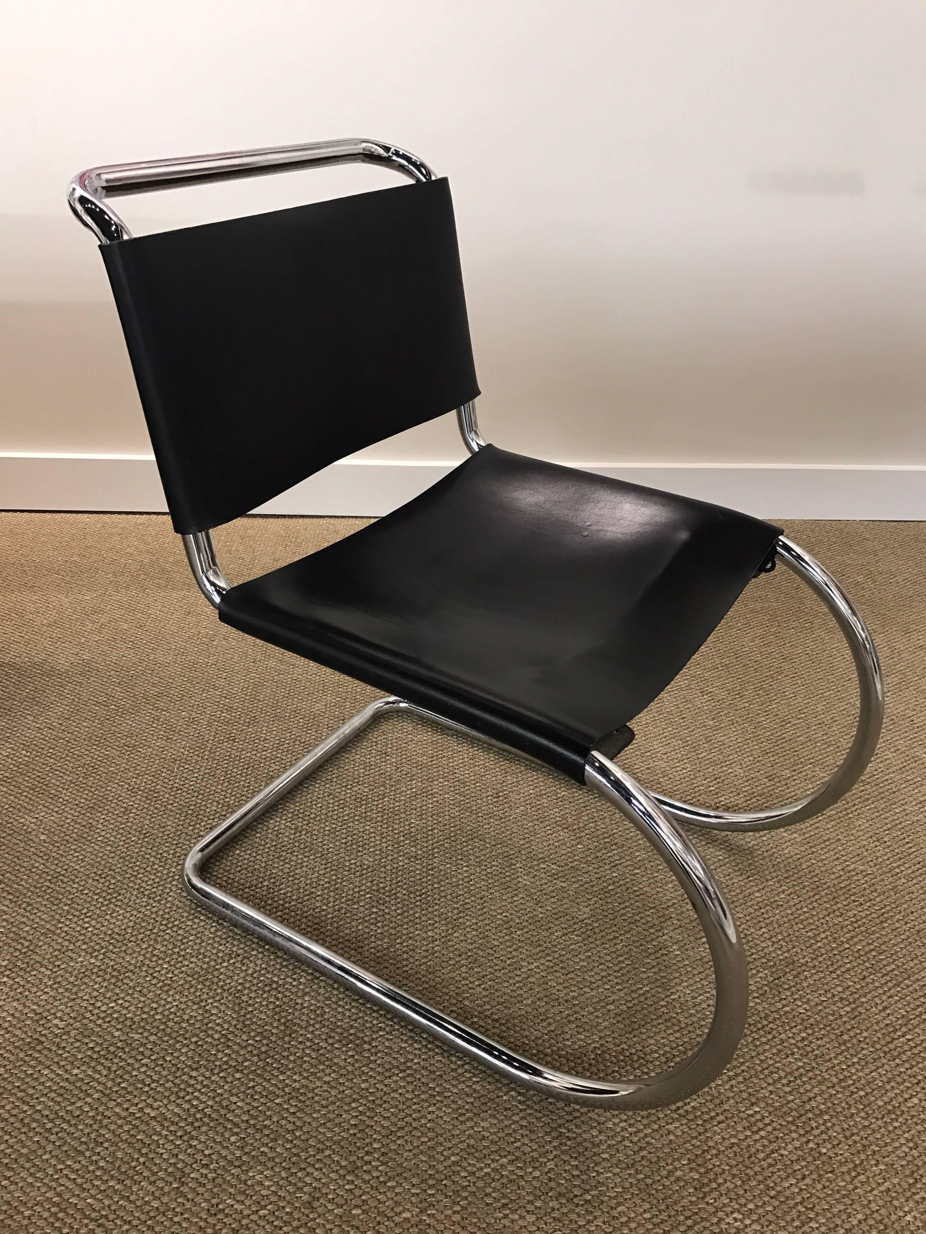 This set of four 1960s Mid-Century Modern style dining room chairs have a unique shaped steel tubular frame with a chrome finish and features a corseted back and seat. The floating frame has a curved front with a square backrest and chair handle.