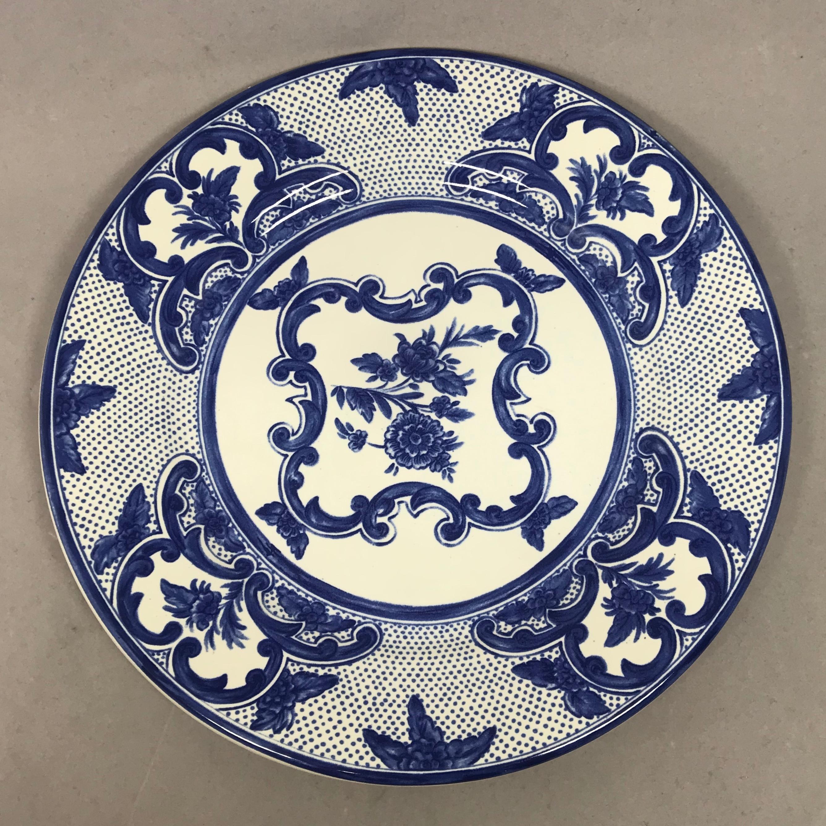 Set of four blue and white Tiffany delft plates. Blue and white ceramic luncheon plates with floral scroll motif, polka dot accents at borders with markings for Tiffany & Co at undersides, Portugal, 1996. 
Dimensions: 8.25