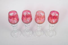 Set of four Bohemian crystal red wine glasses with flowers and grapes motif.