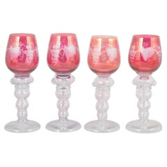 Set of four Bohemian crystal red wine glasses with flowers and grapes motif.