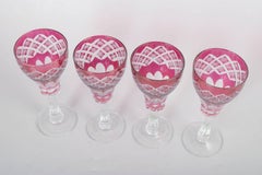 Set of four Bohemian pink crystal wine glasses with cut decoration. 1940s