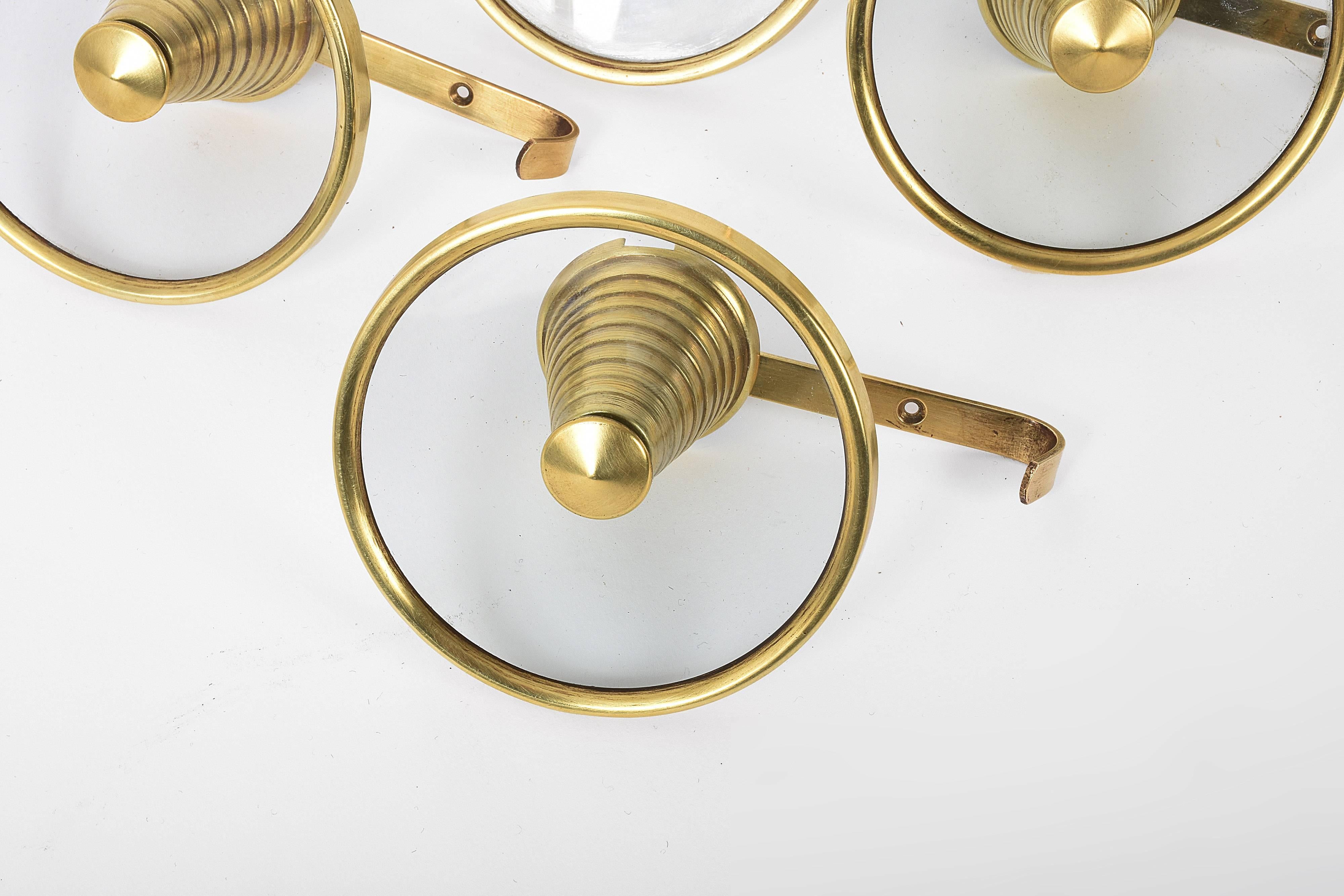 Set of four brass and glass coat hooks attributable to Fontana Arte, Italy, 1950s.