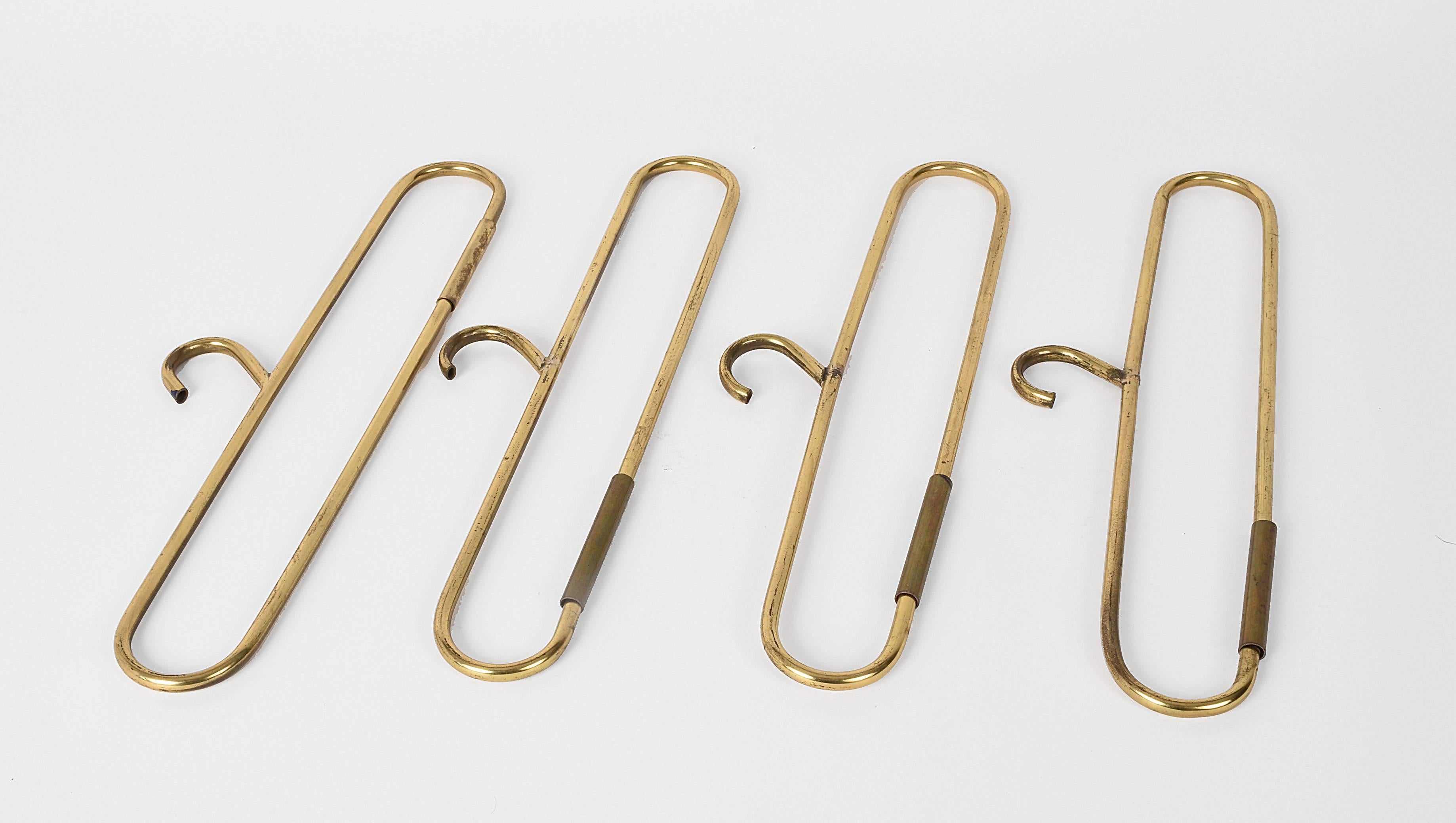 Set of four brass coat hangers. 