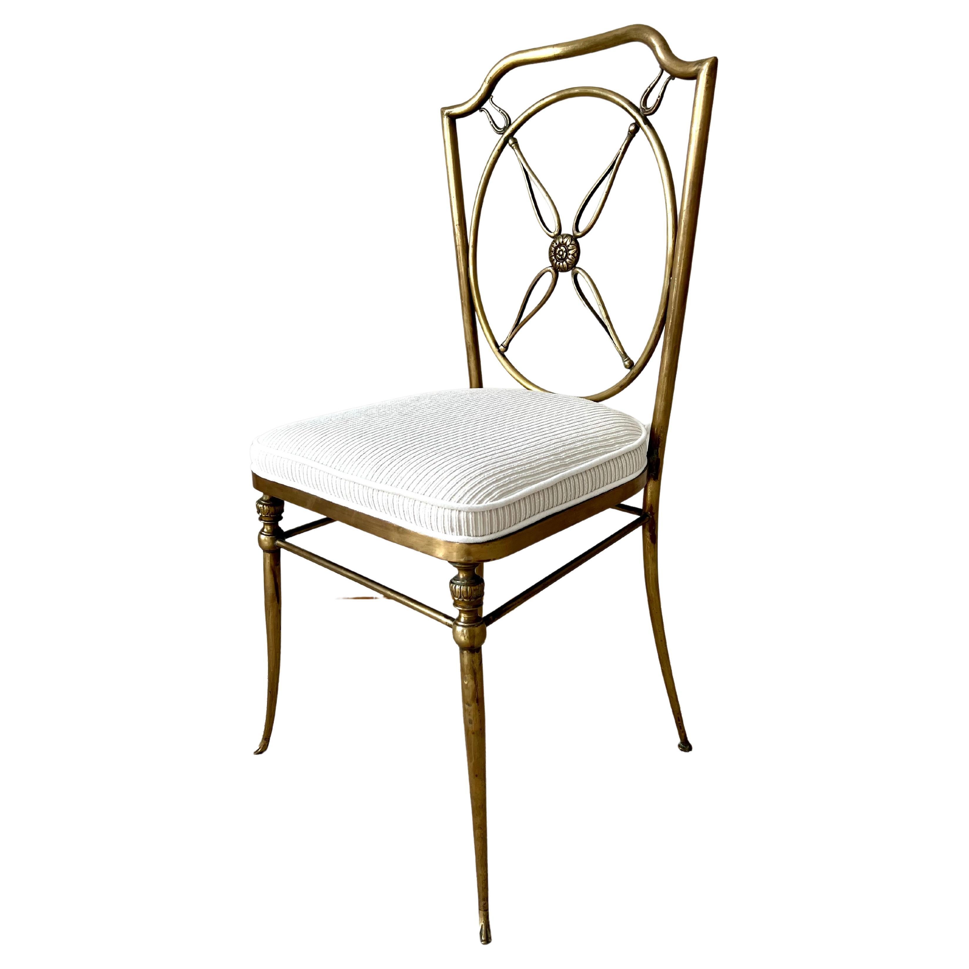 Ensemble de quatre chaises en laiton dans le style de Gio Ponti, avec un dossier en forme de compas et des détails floraux. Le magnifique laiton patiné est complété par des coussins nouvellement rembourrés présentant une subtile rayure chatoyante. 

