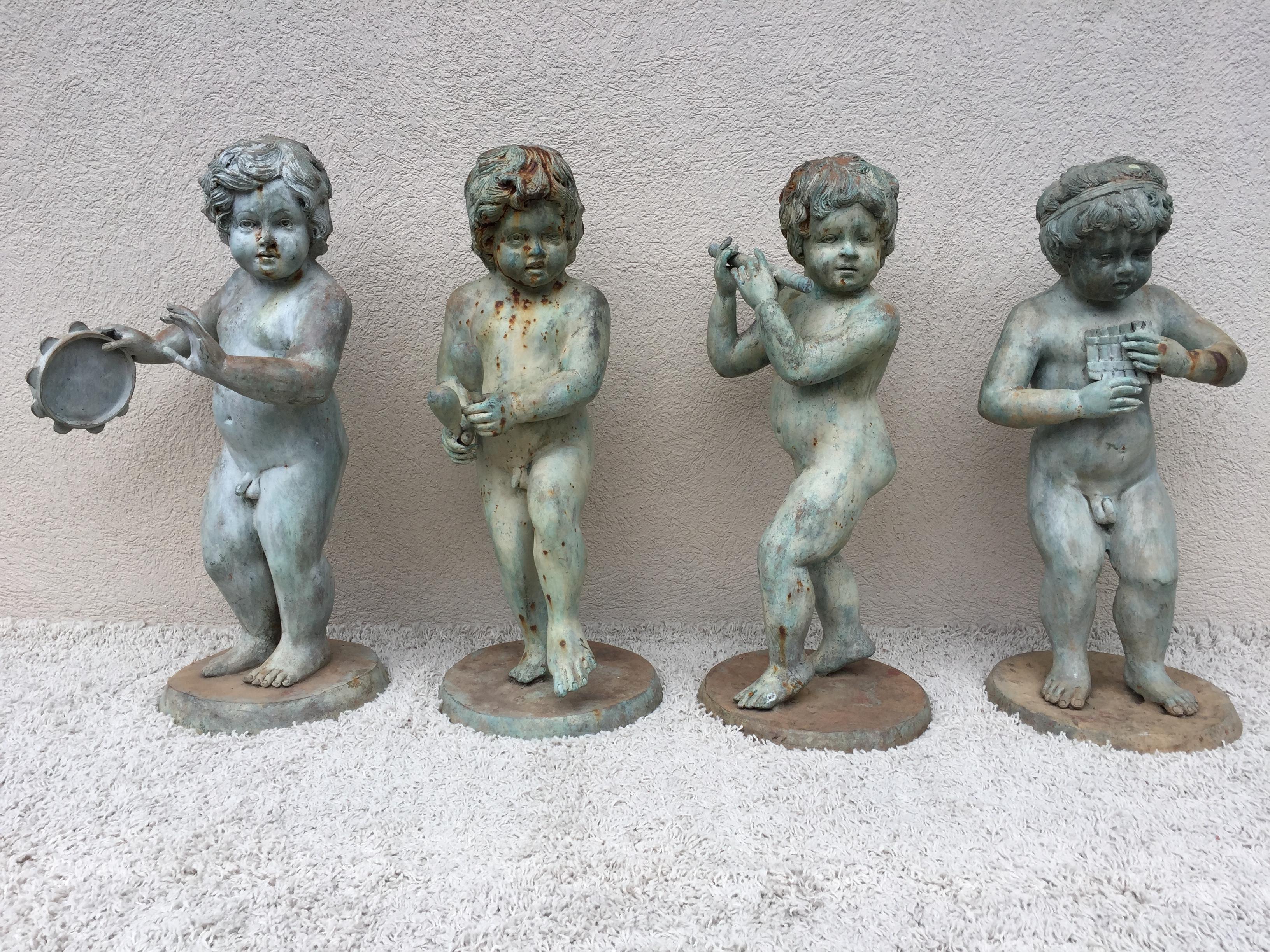Bronze musical Putti or Cherub garden statues set of four, with original patina, whimsical classical 1930s. Measurement of 13 equals the base, they are 17-18 diameter.