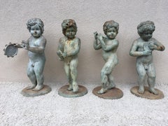 Ensemble de quatre statues de jardin en bronze de style classique avec putti musical ou chérubin