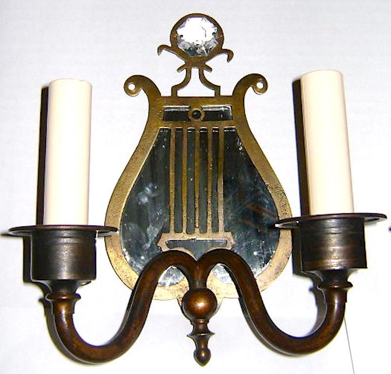 A set of four, circa 1920s American lyre shaped double arm sconces with mirrored backs. 

Priced in pairs.

Measurements: 
Height:  8.75