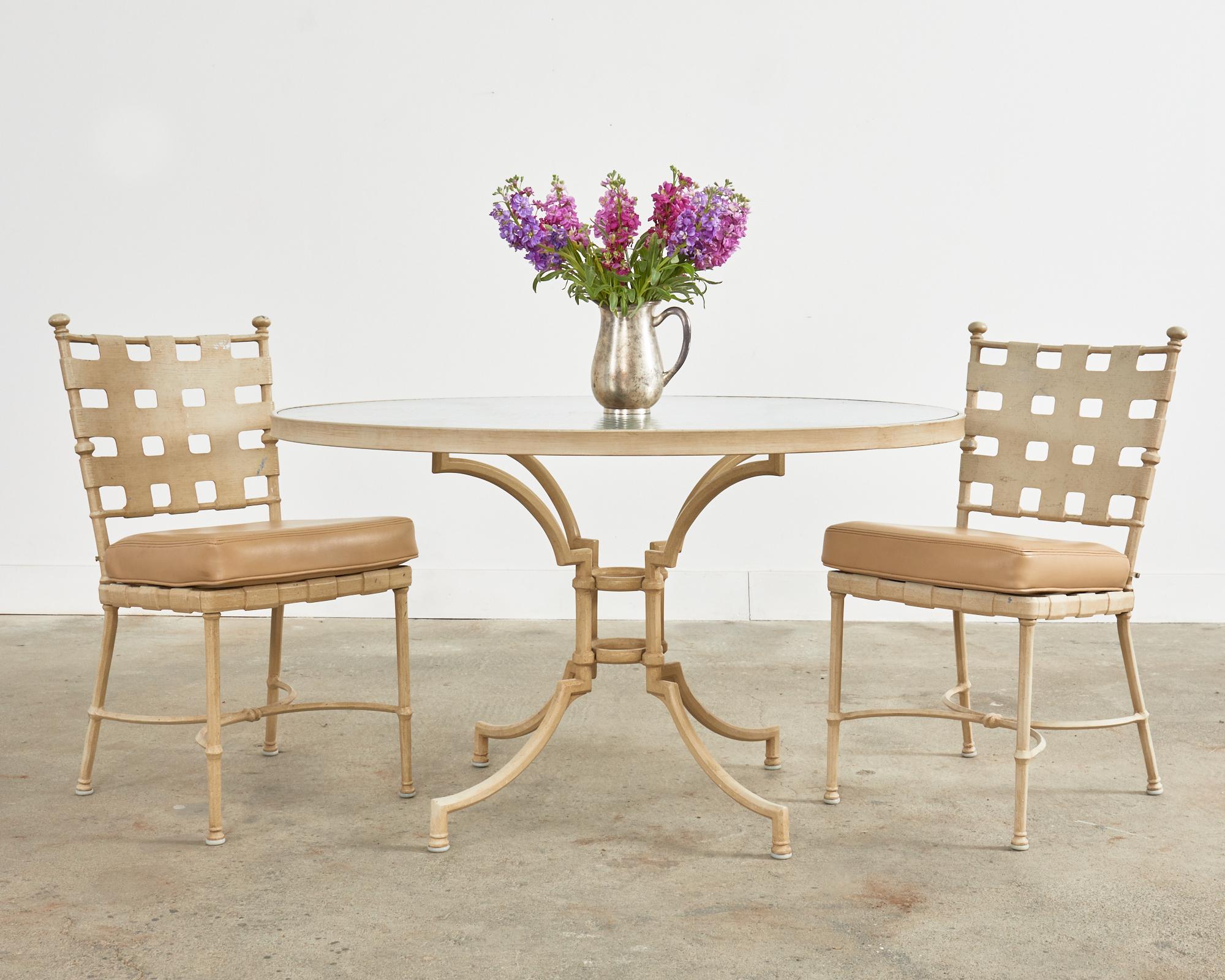 Neoclassical style set of four patio and garden dining chairs made by Brown Jordan. Heavy and solid cast aluminum construction with a lattice design influenced by Mario Papperzini for John Salterini. The chair backs also have the iconic ball finials