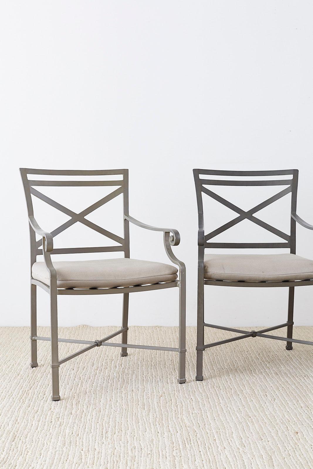 Powder coated set of four Brown Jordan Venetian armchairs for the patio or garden. Featuring a gray finish with neoclassical styling. Each chair has a square back with an X-motif on the splat and leg stretchers. The arms have a decorative scrolled