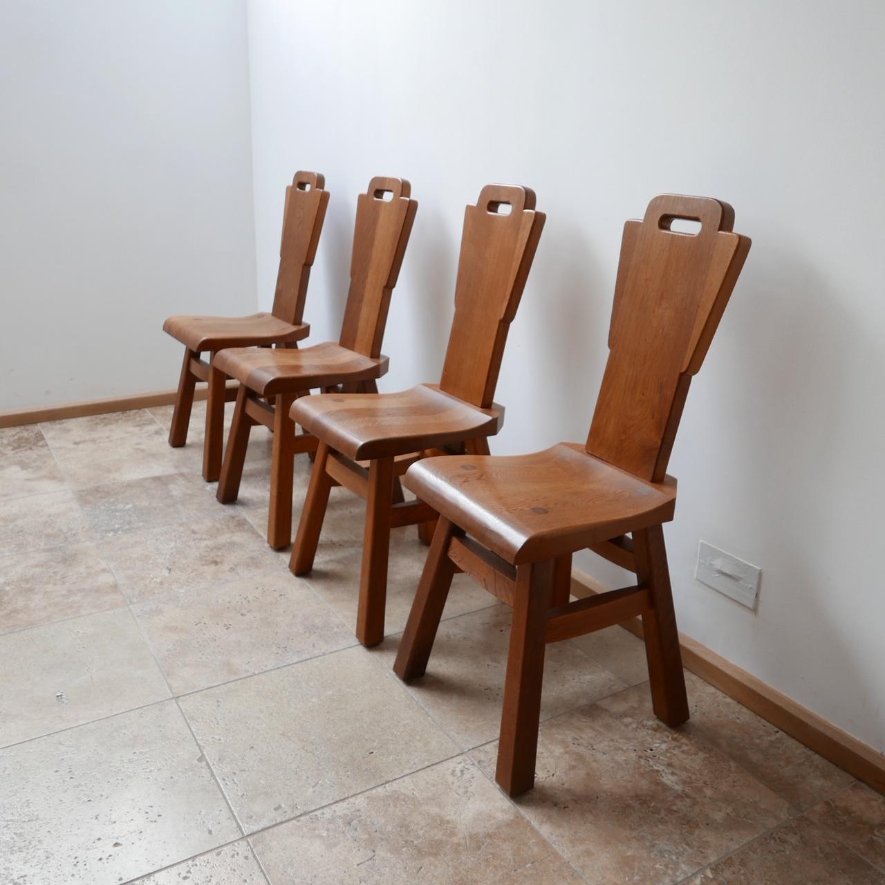 A set of four oak dining chairs.

Brutalist style, Belgium, circa 1970s.

Immense quality of construction using no nails, just quality woodwork in the manner of construction that Pierre Chapo often did his work.

Solid oak, good looking form