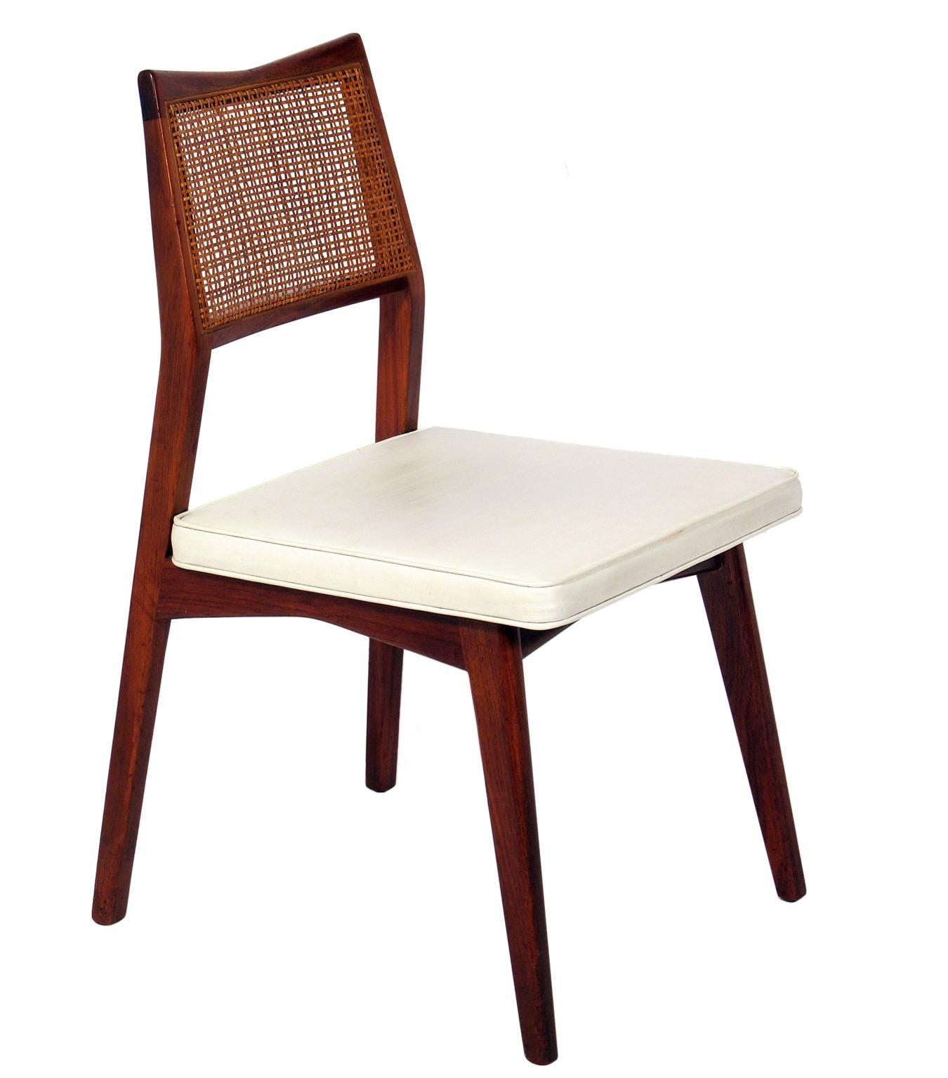 Set of four caned back midcentury dining chairs, attributed to Jens Risom, American, circa 1960s. They have the Danish modern styling that Risom was influenced by, and many of his signature details such as the angled backrests. The original vinyl