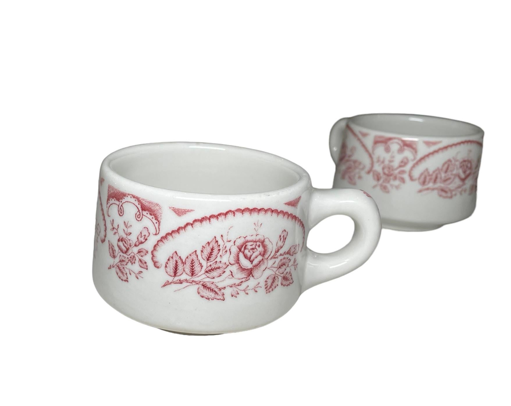 This is a set of four Caribe China coffee/hot chocolate cup. It depicts a heavy and round white cups hand painted cranberry color with little bouquets of roses around them. The bouquets are semi framed with scalloped borders of the same color. Also,
