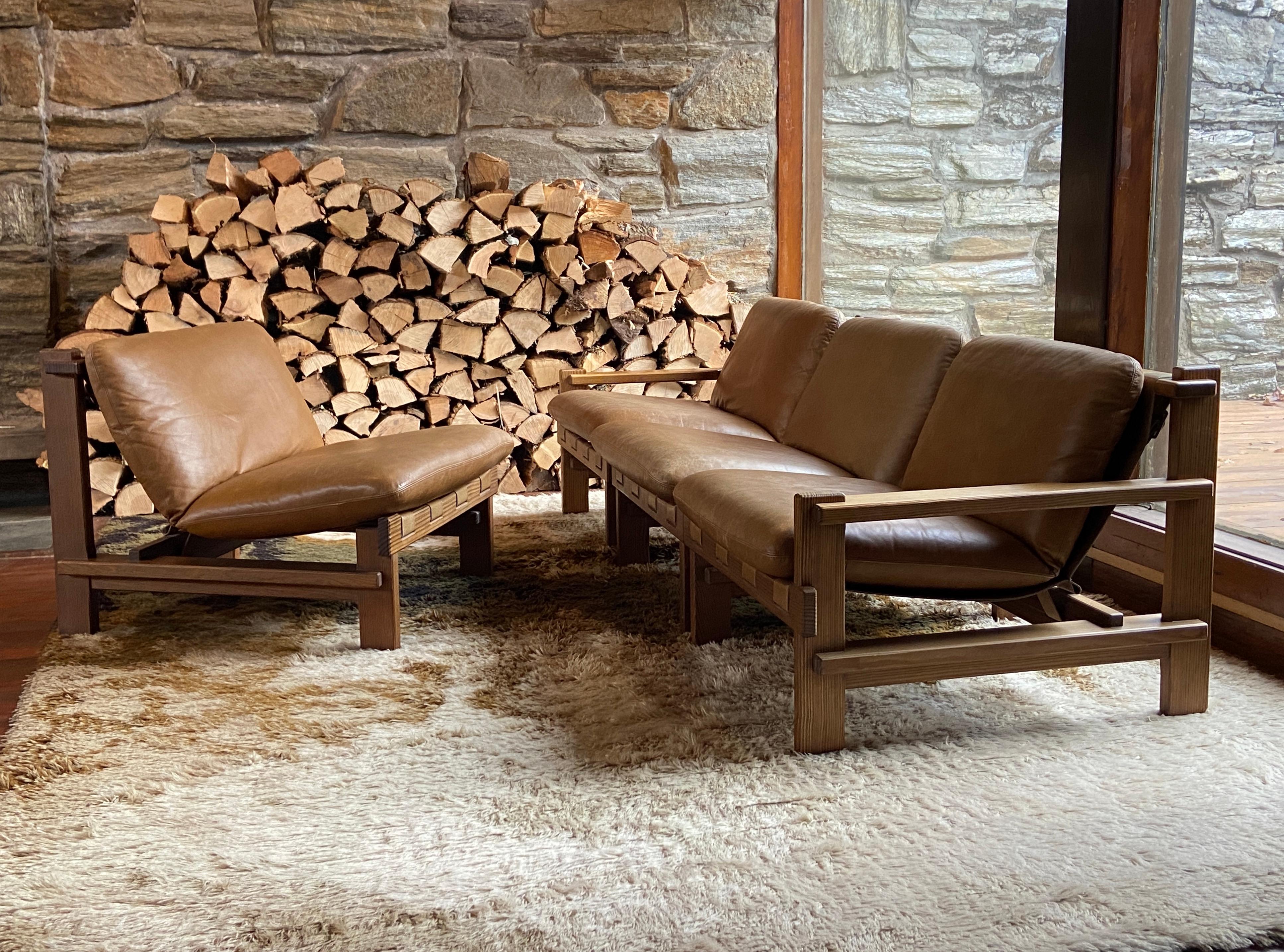 Fantastique ensemble de quatre chaises de salon brutalistes Carl Straub en pin et cuir pouvant être configurées en canapé sectionnel avec de multiples variations. 
Fabriqué en 1974 en Allemagne.
Les grands coussins en cuir reposent sur une écharpe