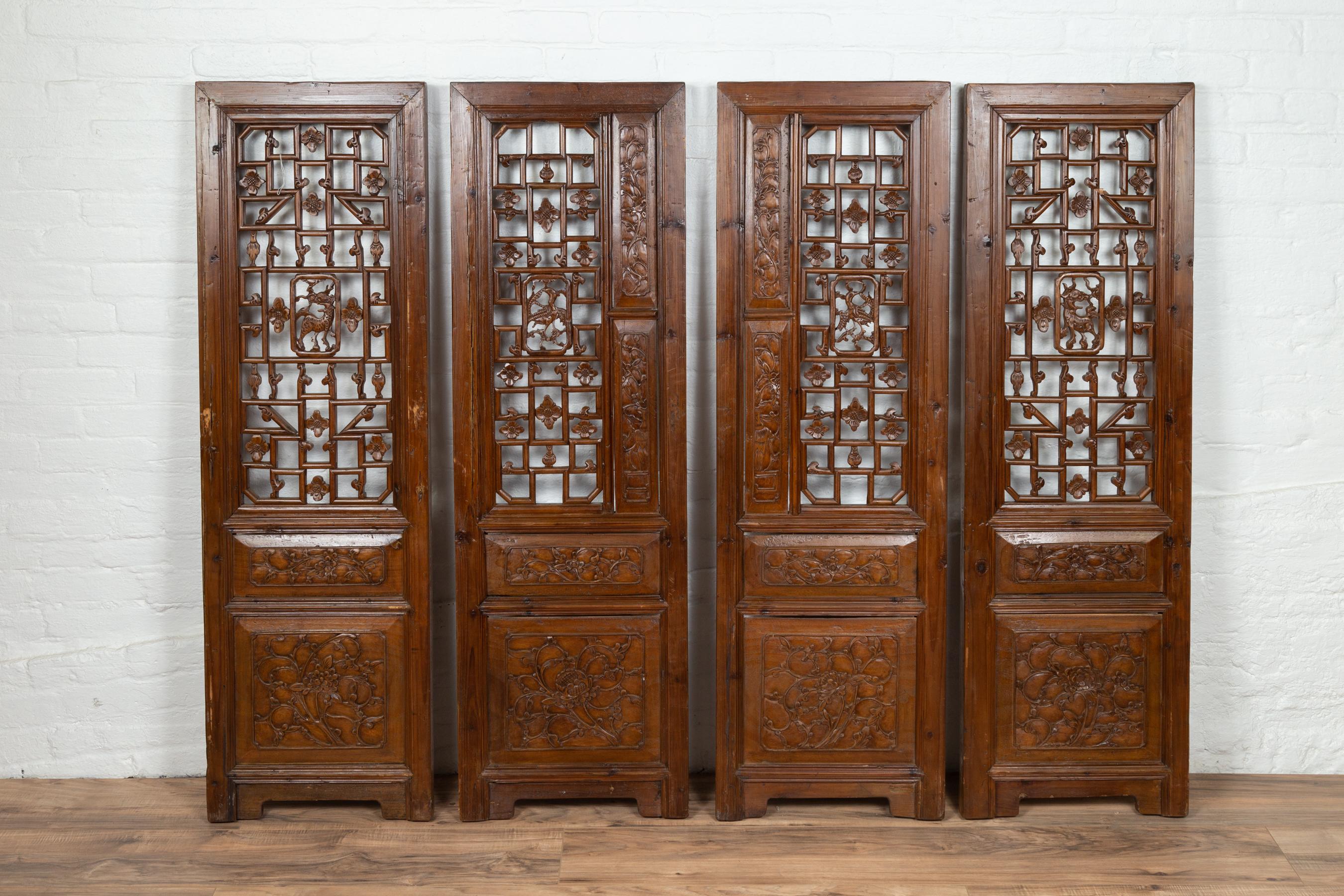 A set of four Chinese carved elmwood screen panels from the 19th century, with fretwork motifs and foliage decor. What is not to love about this set of four screen panels? Presenting a lovely brown patina, each panel is carved with exquisite motifs.