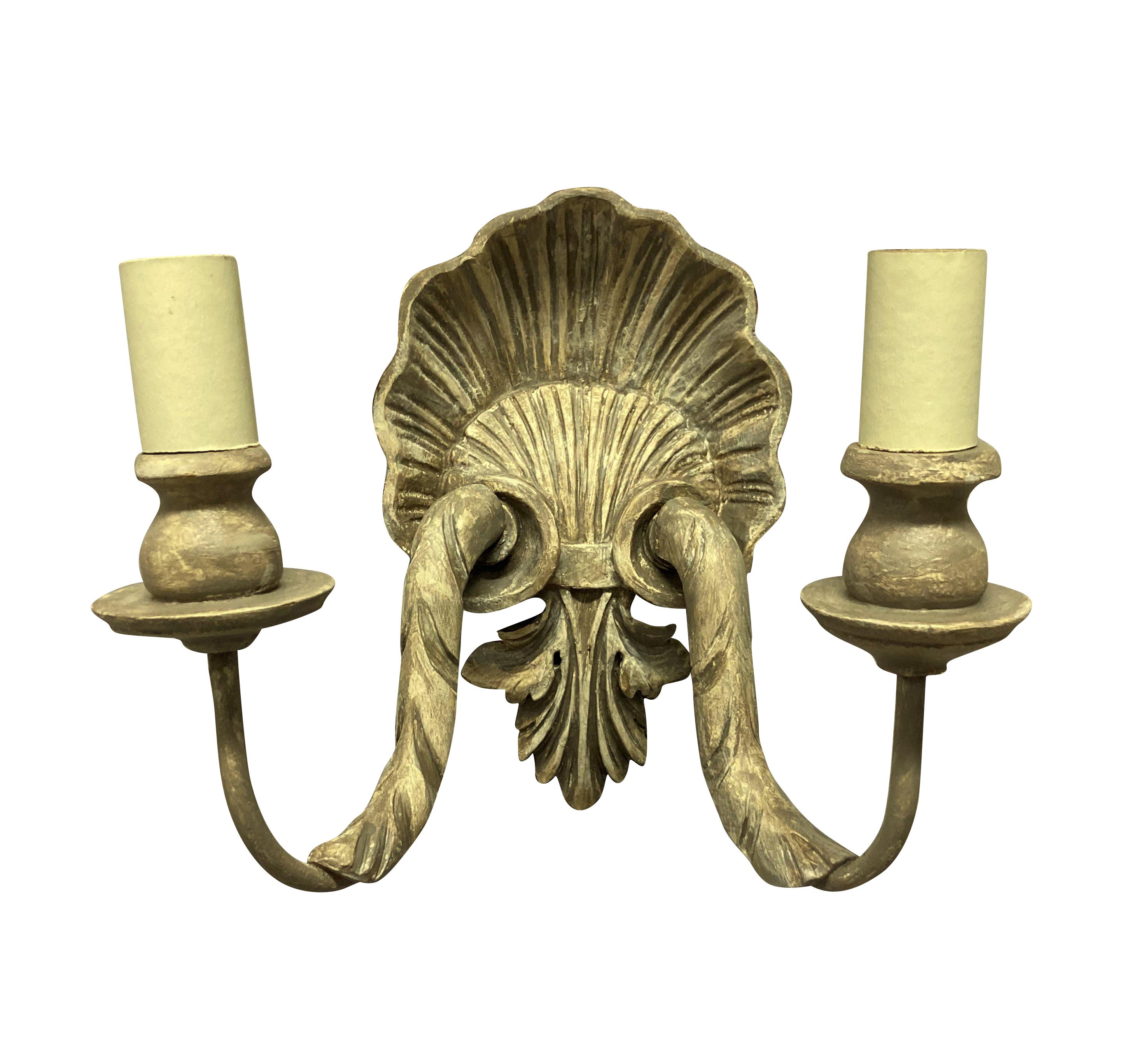 A set of four French carved and painted twin branch shell wall sconces.