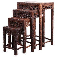 Ensemble de quatre tables gigognes chinoises en bois exotique massif sculpté