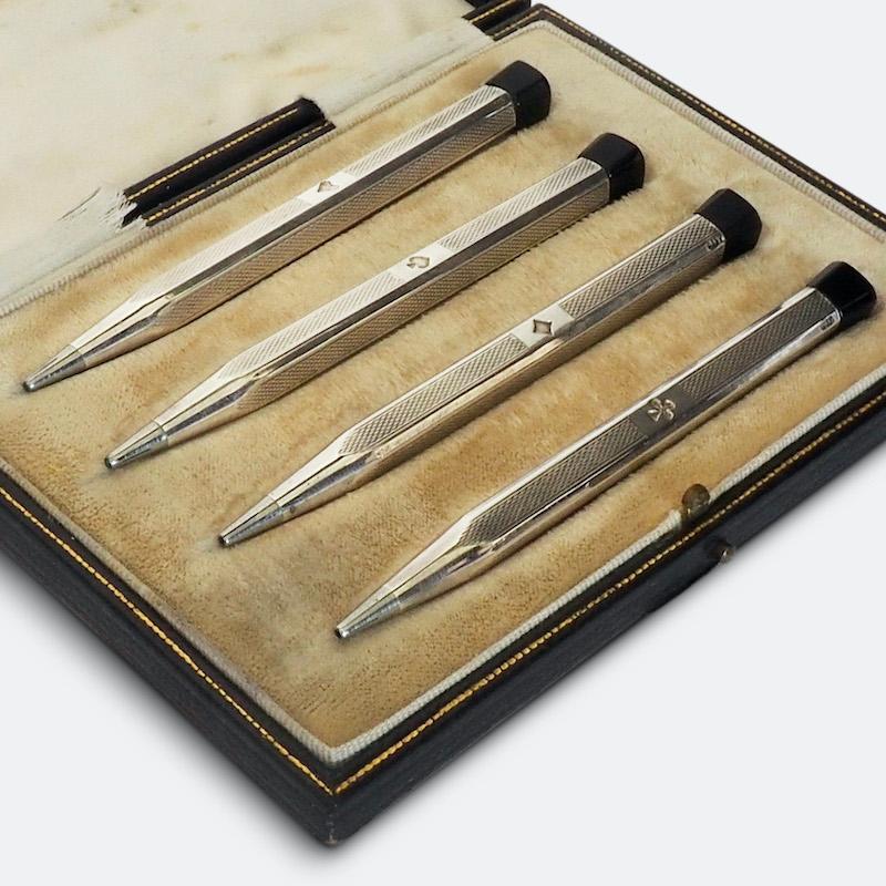 Set of four retractable silver bridge pencils in their original case. 
The pencils have rolled engraved bodies each stamped with an individual suit; hearts, diamonds, clubs and spades. Stamped 935. Housed in the original gilt tooled fitted case.