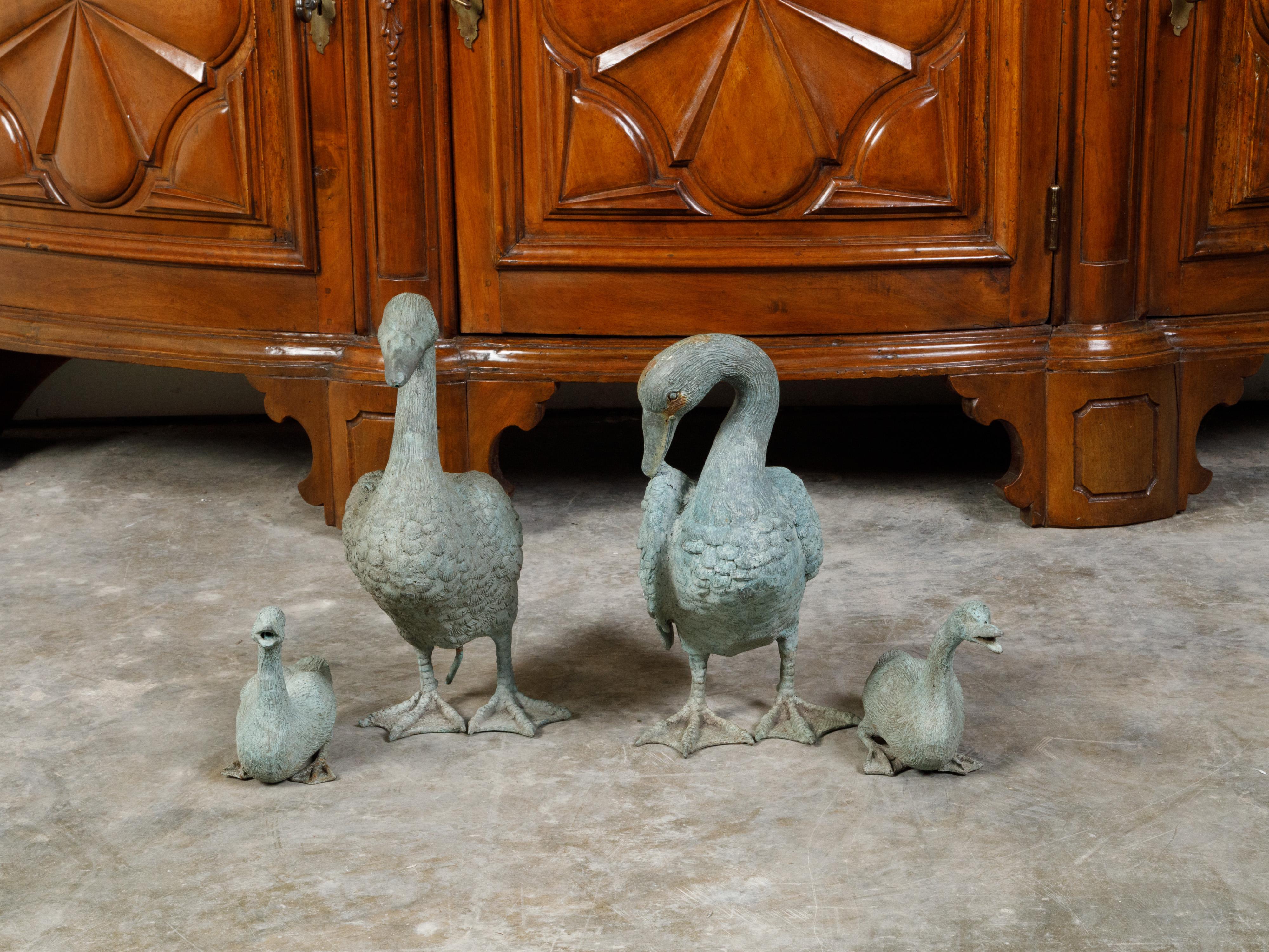 A set of four French bronze duck sculptures from the mid 20th century, depicting two adults and two babies. Created in France during the midcentury period, this sculpted group charms us with its lovely depiction of a family of ducks made of the two