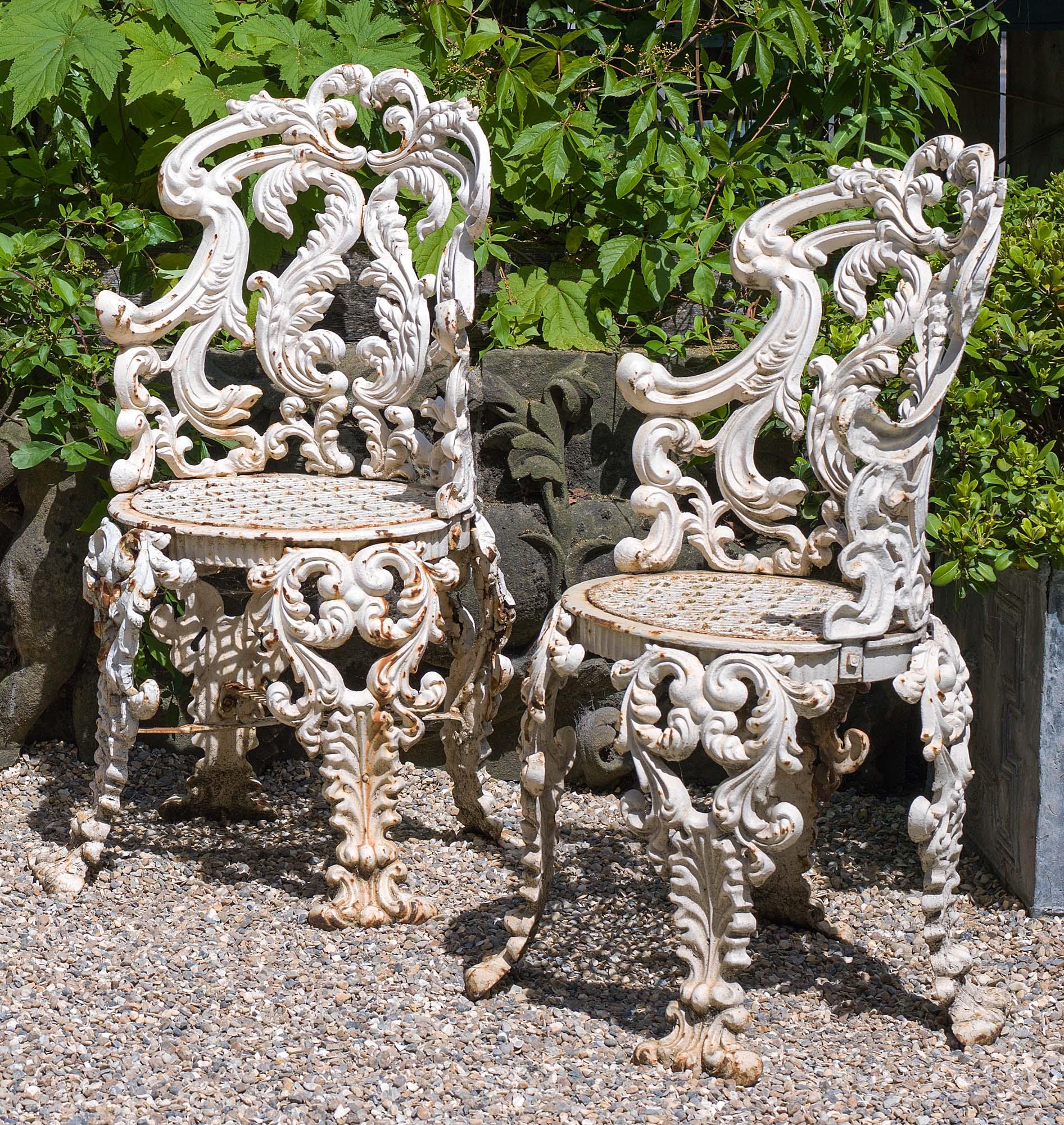 A set of four highly ornate and elegant cast iron Victorian antique garden or conservatory chairs in the Rococo style with oval shaped acanthus scrolled backs, detatchable seats and quadruple splayed legs, English, circa 1850.