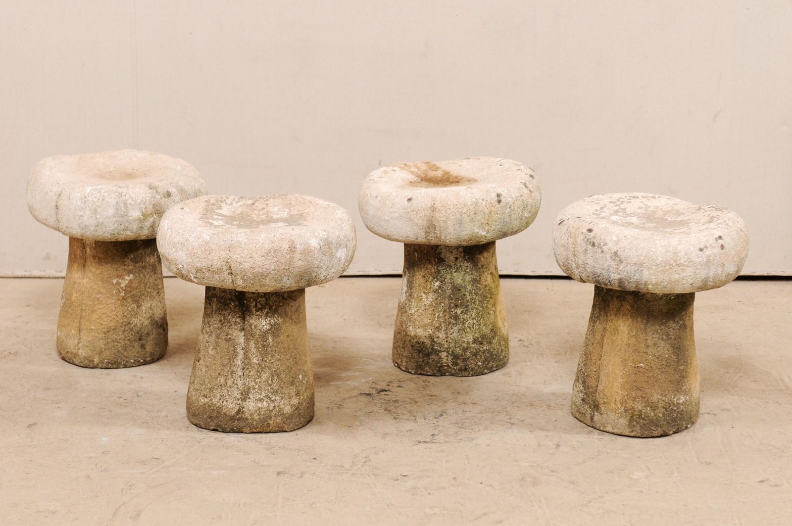 A set of four French outdoor mushroom stools from the late 20th century. This French grouping of stools for your patio or garden are made of cast stone and have a wonderful patina which makes them look as if they have come to life. These French