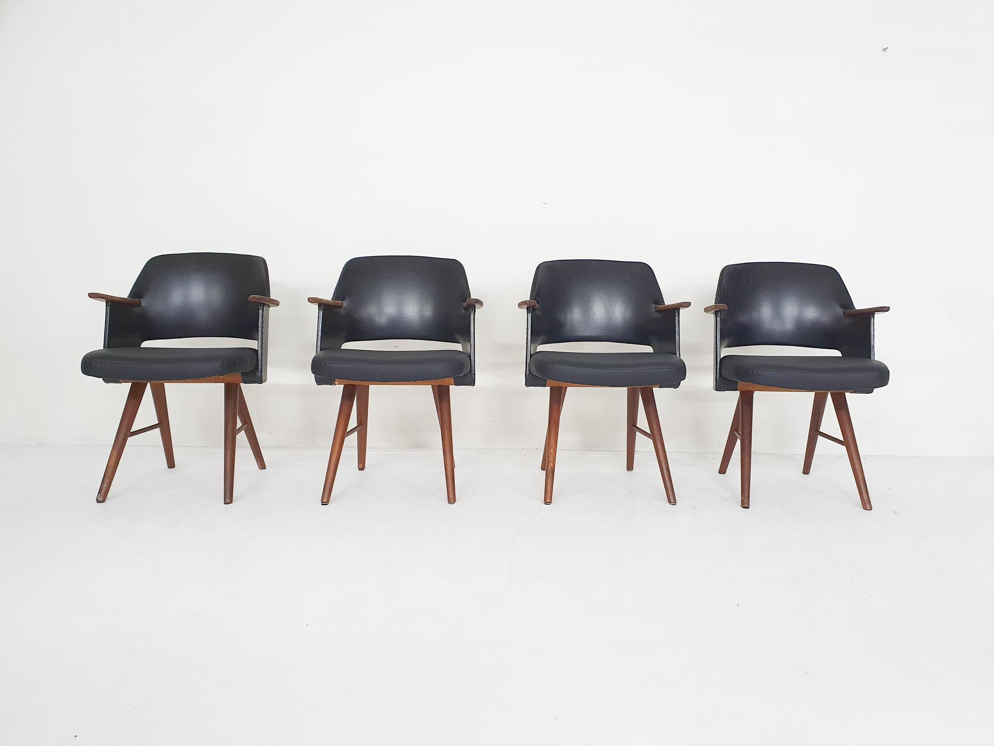 Teak dining chairs with black faux-leather upholstery. The seating has been reupholstered in black vinyl. The back has the original black vinyl upholstery.
One leg has a repair at the foot.

Chairs are marked at the bottom

Height of the arm rests
