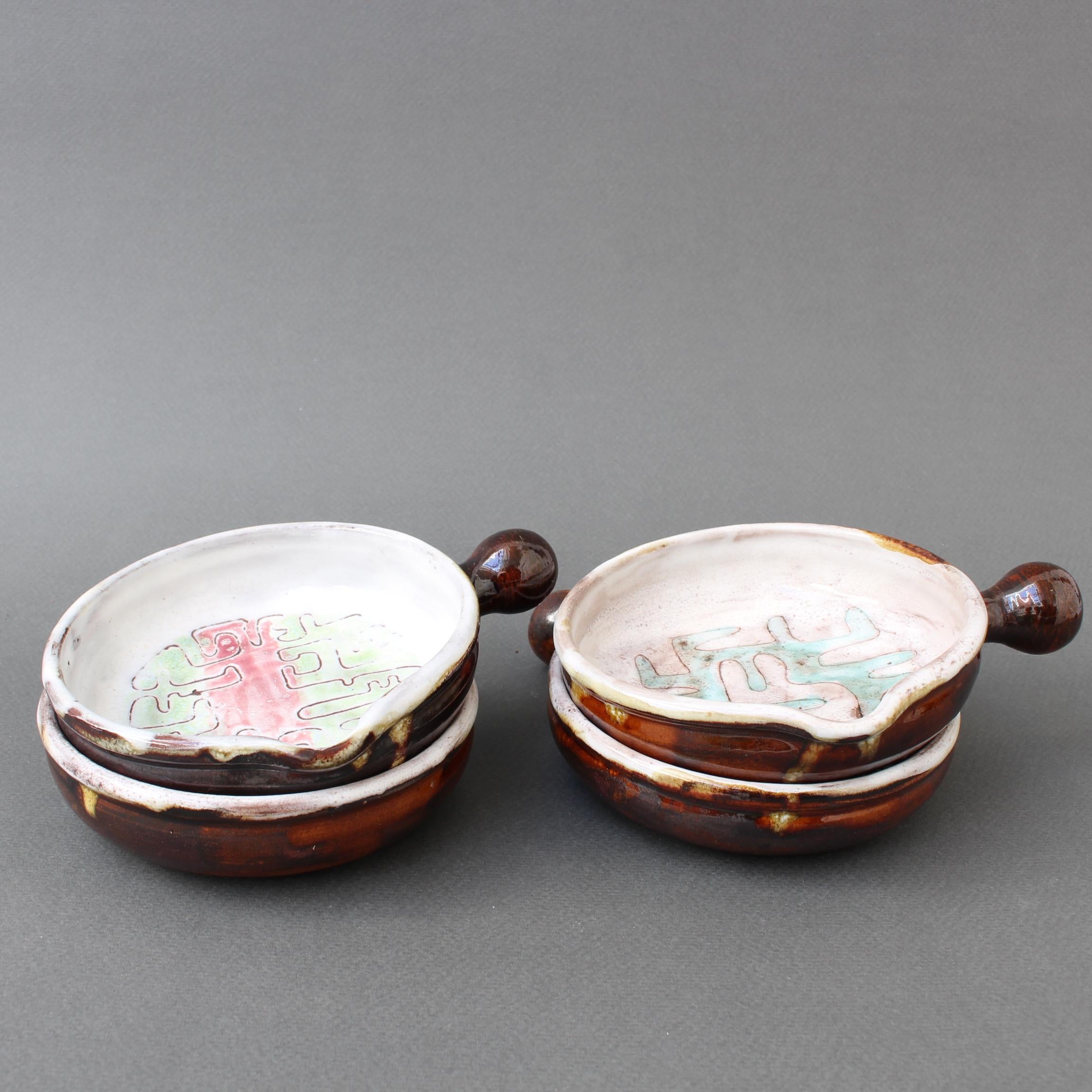 Set of four Mid-Century French small ceramic serving dishes by Jean & Juliette Rivier (circa 1960s). The bases of the dishes are decorated with colourful modern linear designs reminiscent of a labyrinth or graffiti. They may also be somewhat