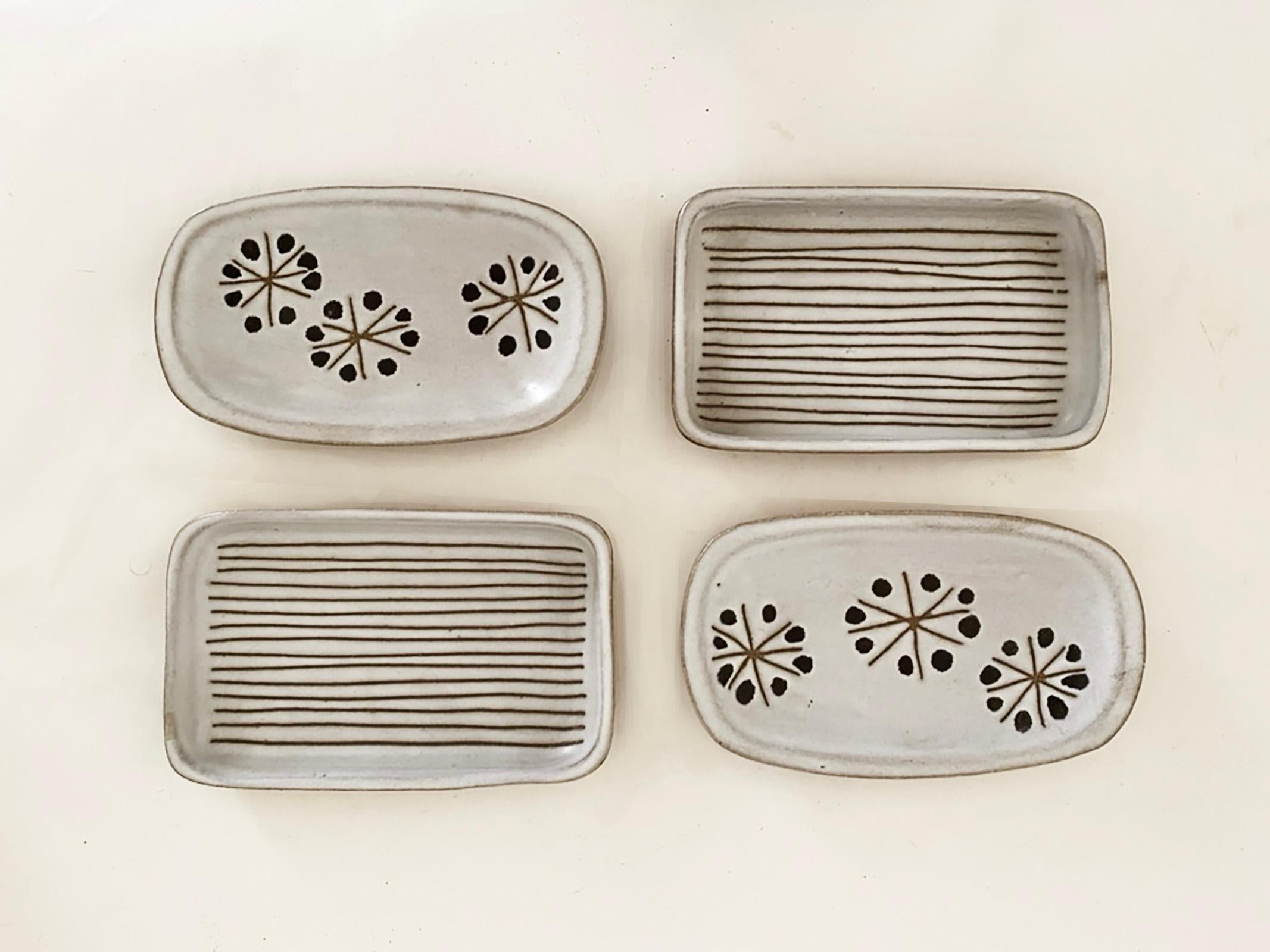 Here is a very nice set of four small trays by Jane and Gordon Martz for Marshall Studios. There are two rectangular trays with a striped sgraffito design and two that are more of an oval shape with an atomic sgraffito motif. All four are signed and