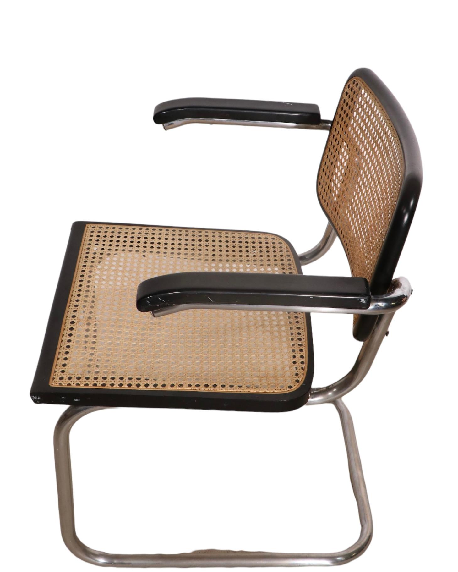 Chic set of vintage Cesca chairs designed by Marcel Breuer, circa 1970's Made in Italy after the Bauhaus originals. The set consists of four arm chairs, having cantilevered chrome frames, wood frames in original black finish, and caned seats and