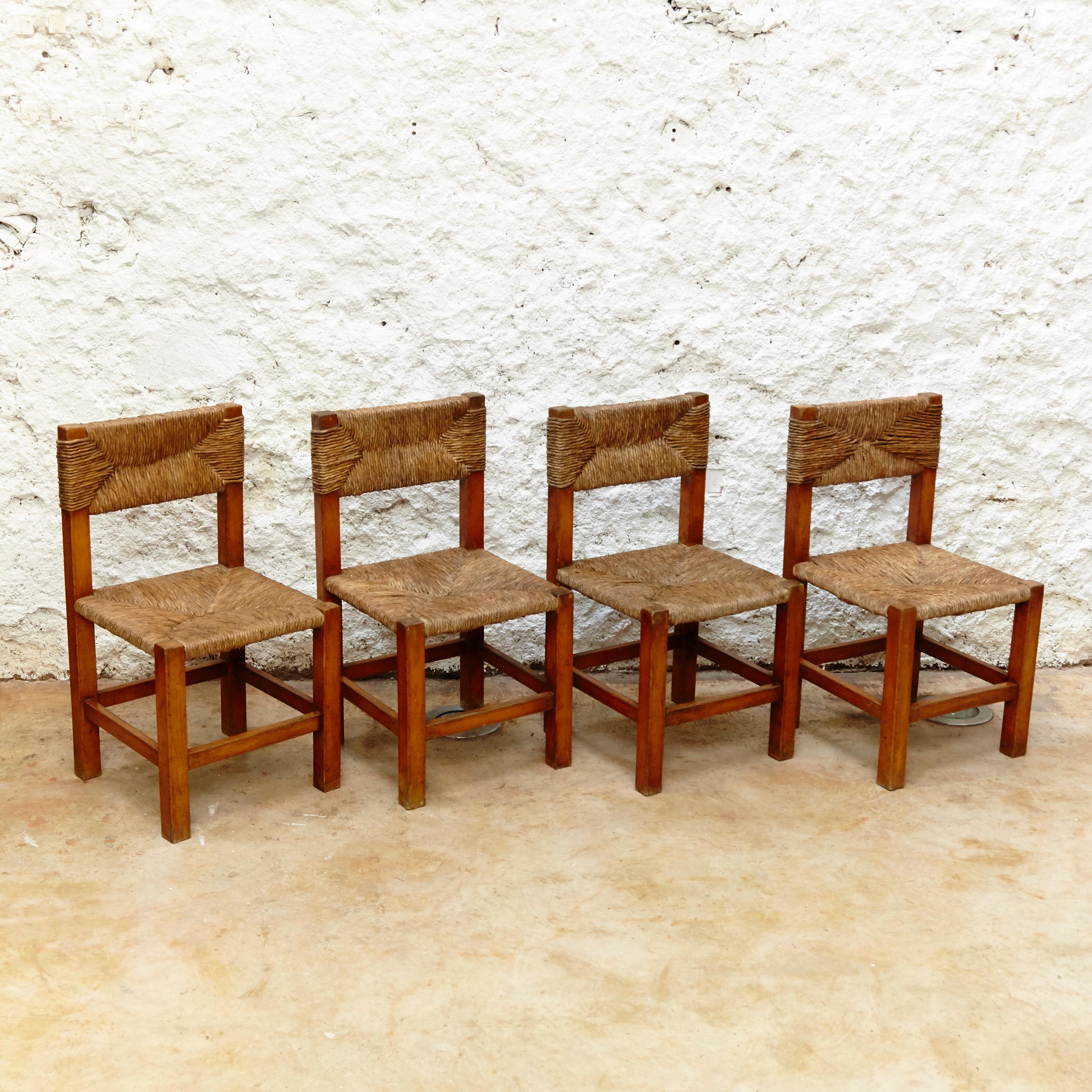 Chairs designed in the style of Charlotte Perriand, made by unknown manufacturer.

Wood and rattan.

In original condition, with minor wear consistent with age and use, preserving a beautiful patina.

Charlotte Perriand (1903-1999) she was