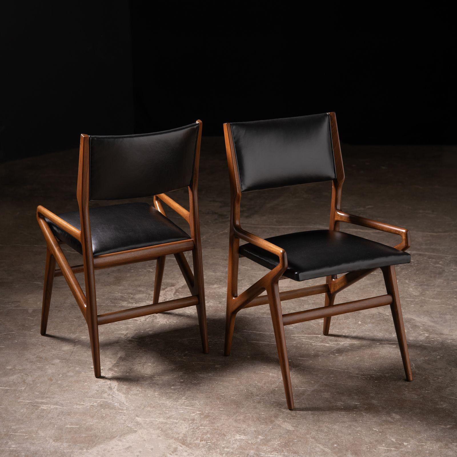 Ensemble de quatre chaises de salle à manger modèle 211 conçu par Gio Ponti, 1955 pour Singer & Sons. La chaise modèle 211 a été conçue à l'origine pour la Villa Arreaza à Caracas en 1954. Les chaises sont en noyer et en cuir et ont été restaurées