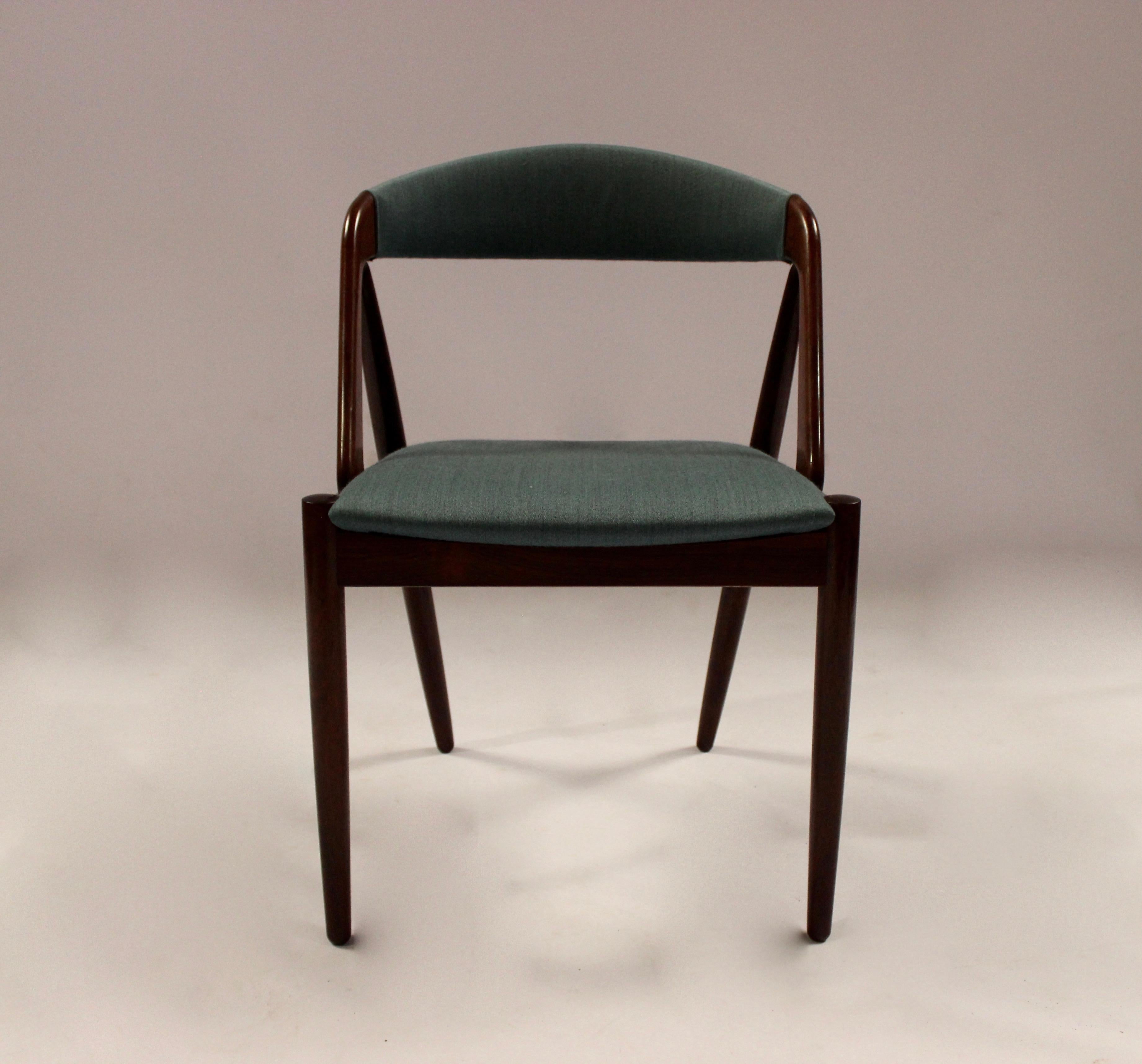A set of four dining room chairs, model 31, designed by Kai Kristiansen in 1956 and manufactured by Schou Andersen in the 1960s. The chairs are of rosewood and upholstered in turquoise fabric.