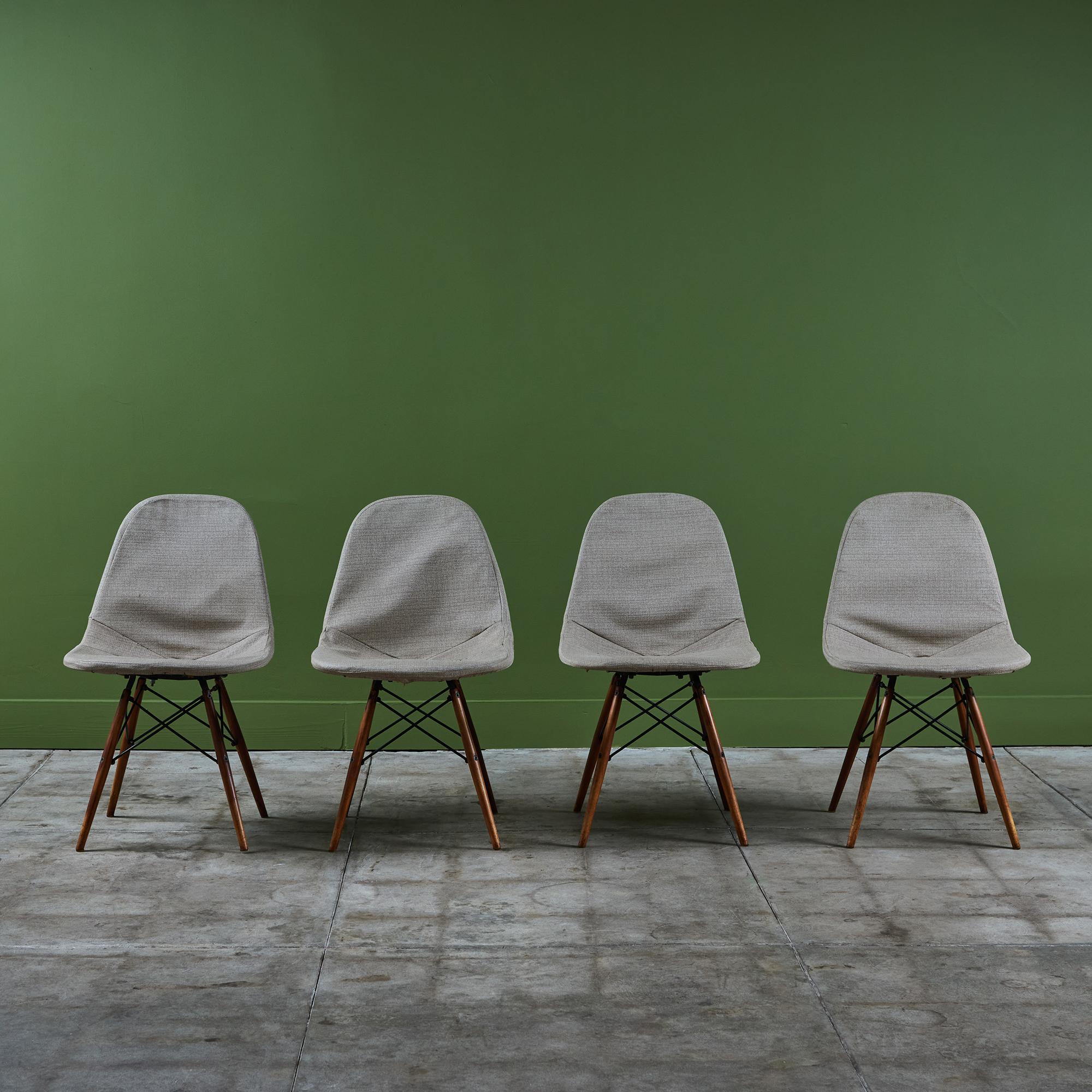 Früher Satz von vier Drahtgestellstühlen von Charles und Ray Eames für Herman Miller. Die Stühle haben grau marmorierte Stoffbezüge über schwarzen Metallrahmen. Jeder Stuhl ruht auf vier gespreizten Holzdübelbeinen.

Markierung [Herman Miller] auf