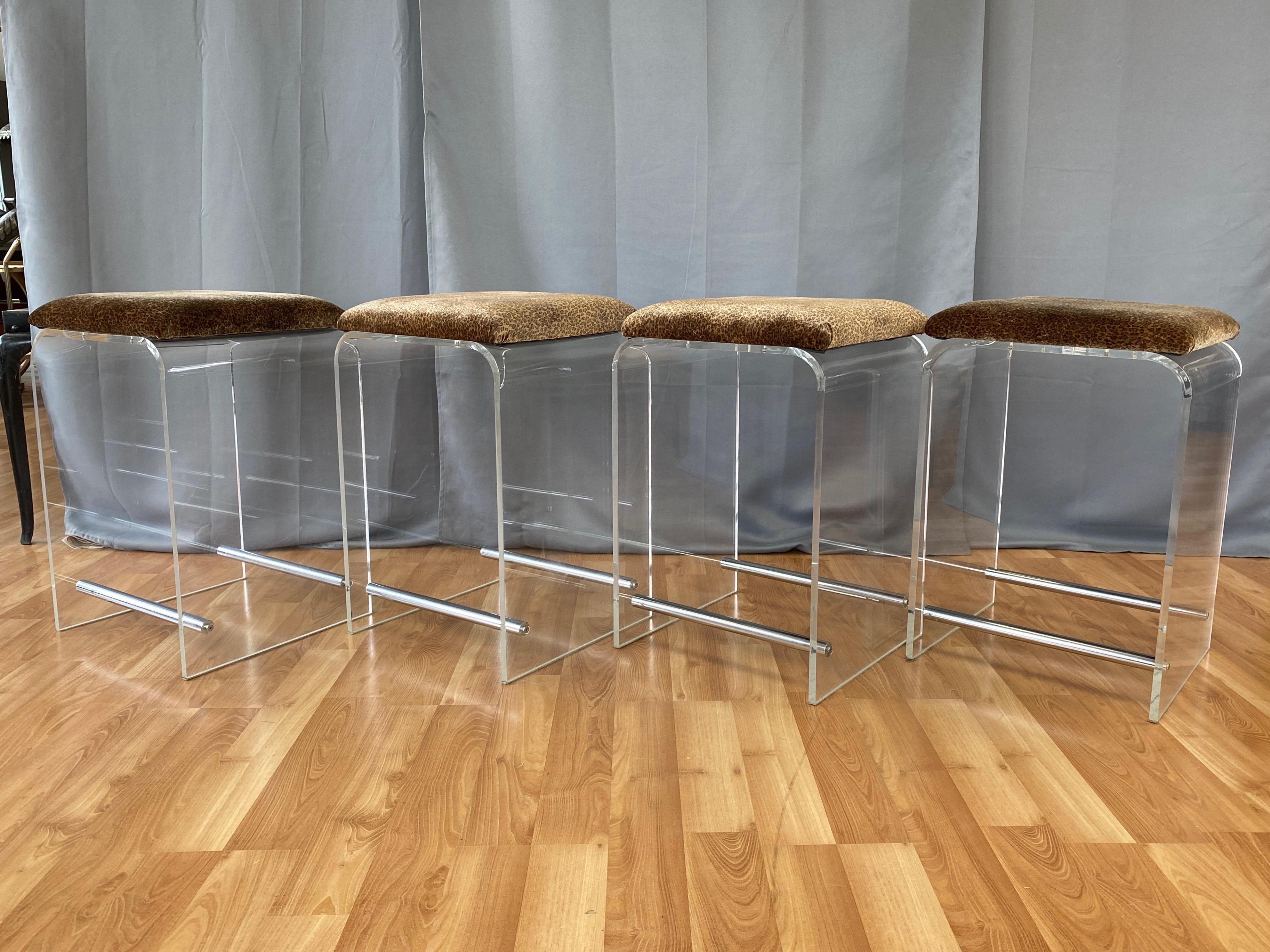 A four-piece set of super chic 1970s lucite counter or low bar stools with velvet seats attributed to Charles Hollis Jones.

Base comprised of a well crafted single piece of .5-inch-thick crystal clear lucite with waterfall top. Sides joined by a