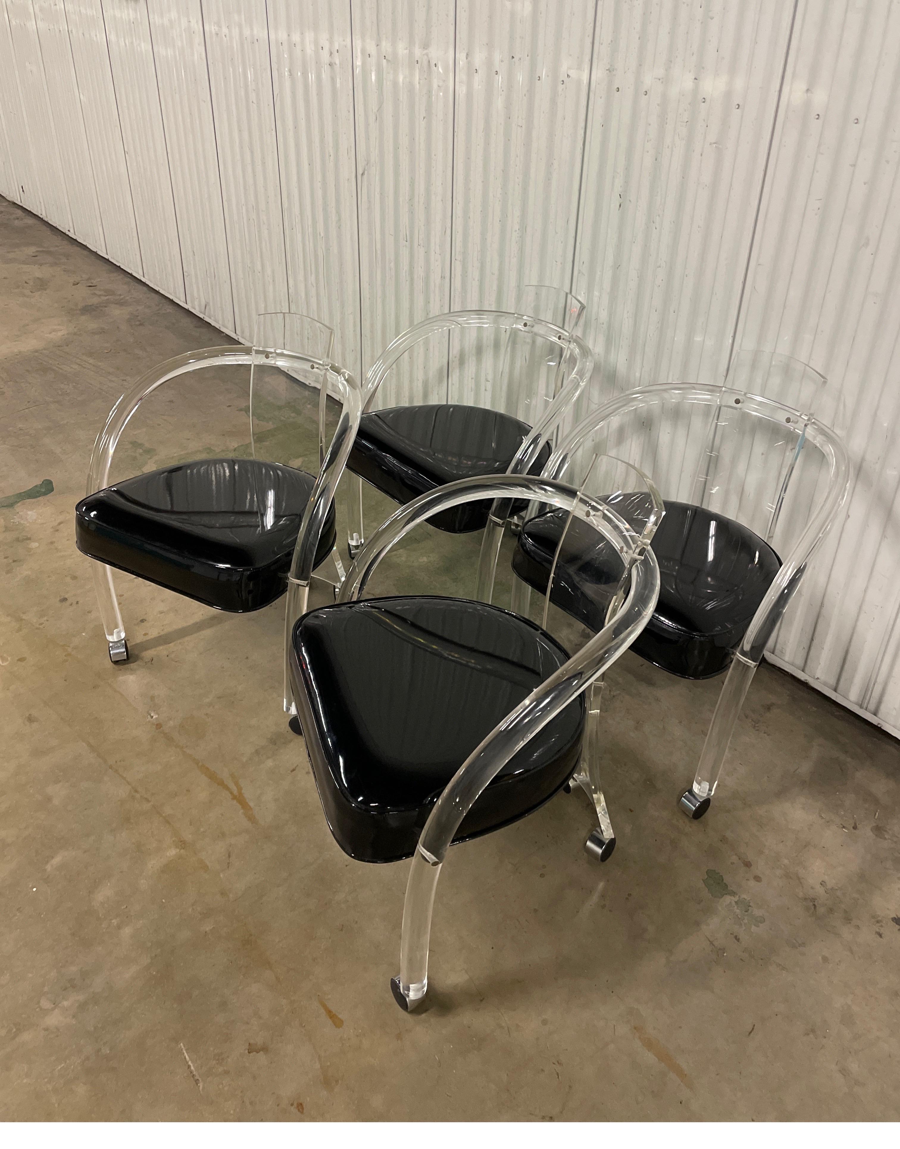 Vintage set of mid century lucite club chairs on casters with original black patent leather seats. These chairs were made by Hill Manufacturers for Charles Hollis Jones.