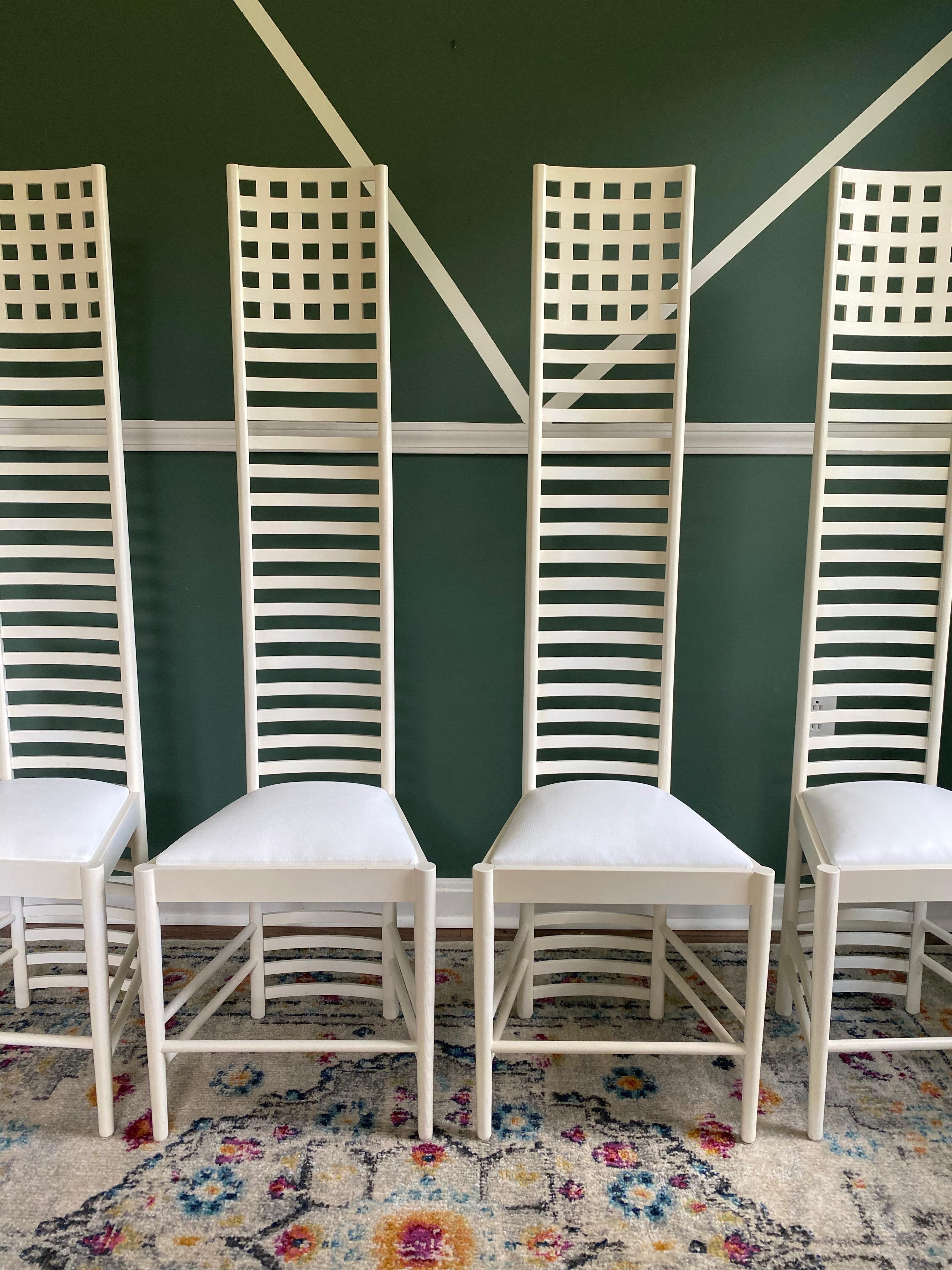 Hard to find..Set of four Charles Rennie Mackintosh-Style high back chairs (by Gordon MFG) reupholstered in white vegan leather. These chairs are made with beautiful white lacquered wood (that was also touched up). These skinny, tall chairs are a
