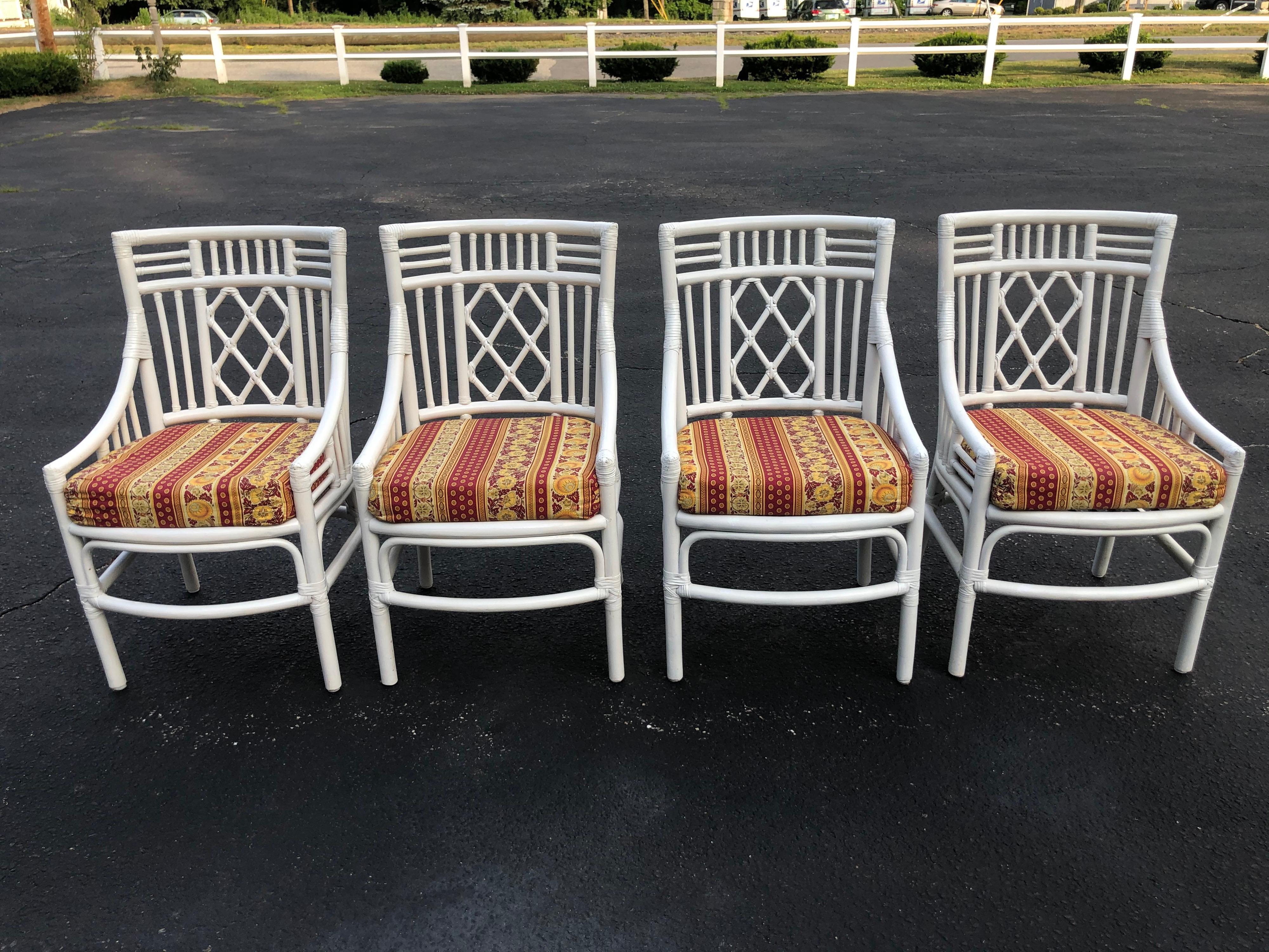 Set of four Chinese Chippendale rattan chairs. Fabulous fretwork design. Hand upholstered seat cushions with zippers in French Pierre Deux high end fabric. Seat depth 18.